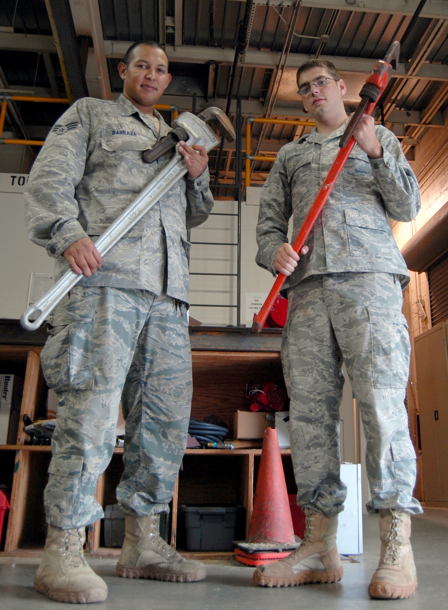 Senior Airman Richard Barraza (left) and Senior Airman James Founds stand with tools in hand, prior to going to a work site July 15, 2010, on Pope Air Force Base, N.C. Airmen Barraza and Founds are 43rd Civil Engineer Squadron plumbers. They are responsible for maintaining and repairing water delivery systems for every facility on Pope AFB. (U.S. Air Force photo/Senior Airman Kris Levasseur)