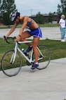 MINOT AIR FORCE BASE, N.D. -- Capt. Tara Hasbrouck, 91st Operation Support Squadron ICBM weapons instructor, rides off on her bike during a triathlon. Captain Hasbrouck was the second female to finish here July 16. Civilian and military members from across the base participated in the triathlon, which consisted of a one-half mile swim, a 10 kilometer bicycling route and a five kilometer run. The 5th Force Support Squadron organized the event to promote physical fitness and team building. (U.S. Air Force photo by Airman 1st Class Aaron-Forrest Wainwright)