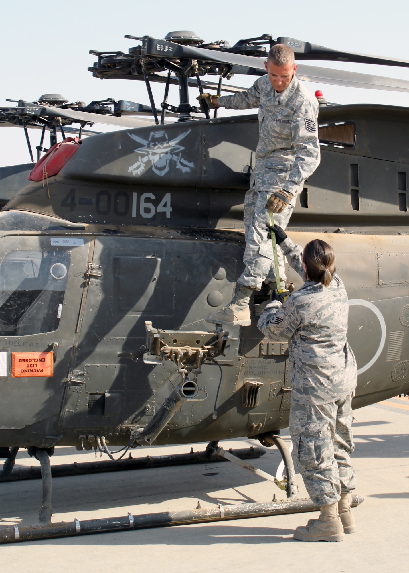 Tech. Sgt. James Dupuis and Staff Sgt. Angel Lombana measure the height of an Army OH-58 Kiowa helicopter during transport preparation July 15, 2010, at Joint Base Balad, Iraq. Sergeants Dupuis and Lombana are from the 332nd Expeditionary Logistics Readiness Squadron. (U.S. Air Force photo/Staff Sgt. Stacy Fowler)