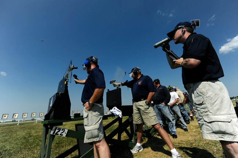 Colonel Mark Teskey, left, and Col. Mark Hays, middle, take shots on target during the Center Fire Team expert .45 caliber competition while Lt. Col. Thomas Reardon, right, provides sight corrections at the 2010 NRA National Pistol Championships July 16 at Camp Perry in Port Clinton, Ohio.  
(U.S. Air Force photo/Staff Sgt. Bennie J. Davis III)