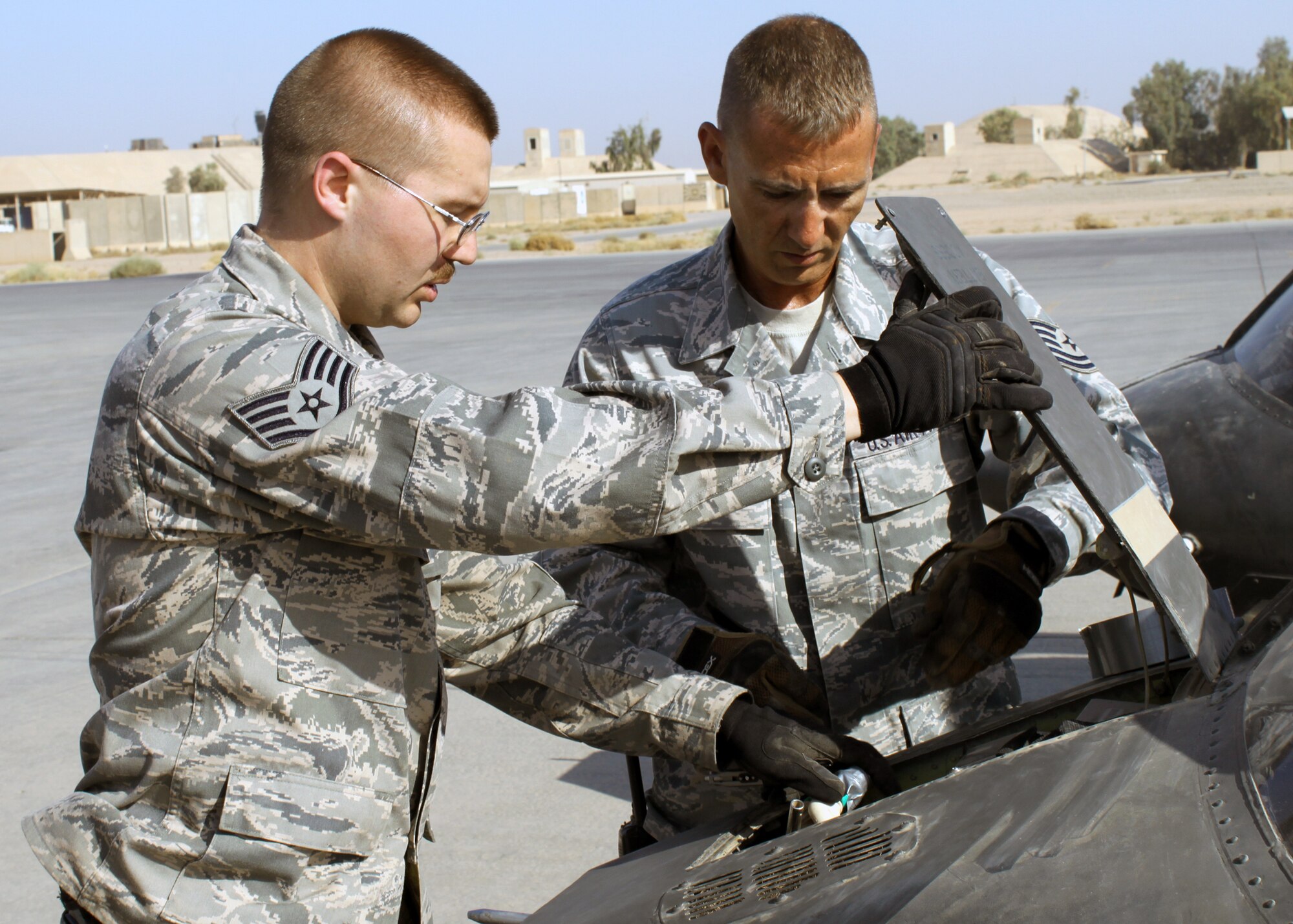 Staff Sgt. Ryan Hockerlotz (left) and Tech. Sgt. James Dupuis disconnect the battery of an Army OH-58 Kiowa helicopter during transport preparation July 15, 2010, at Joint Base Balad, Iraq. Sergeants Hockerlotz and Dupuis are from the 332nd Expeditionary Logistics Readiness Squadron. (U.S. Air Force photo/Staff Sgt. Stacy Fowler)