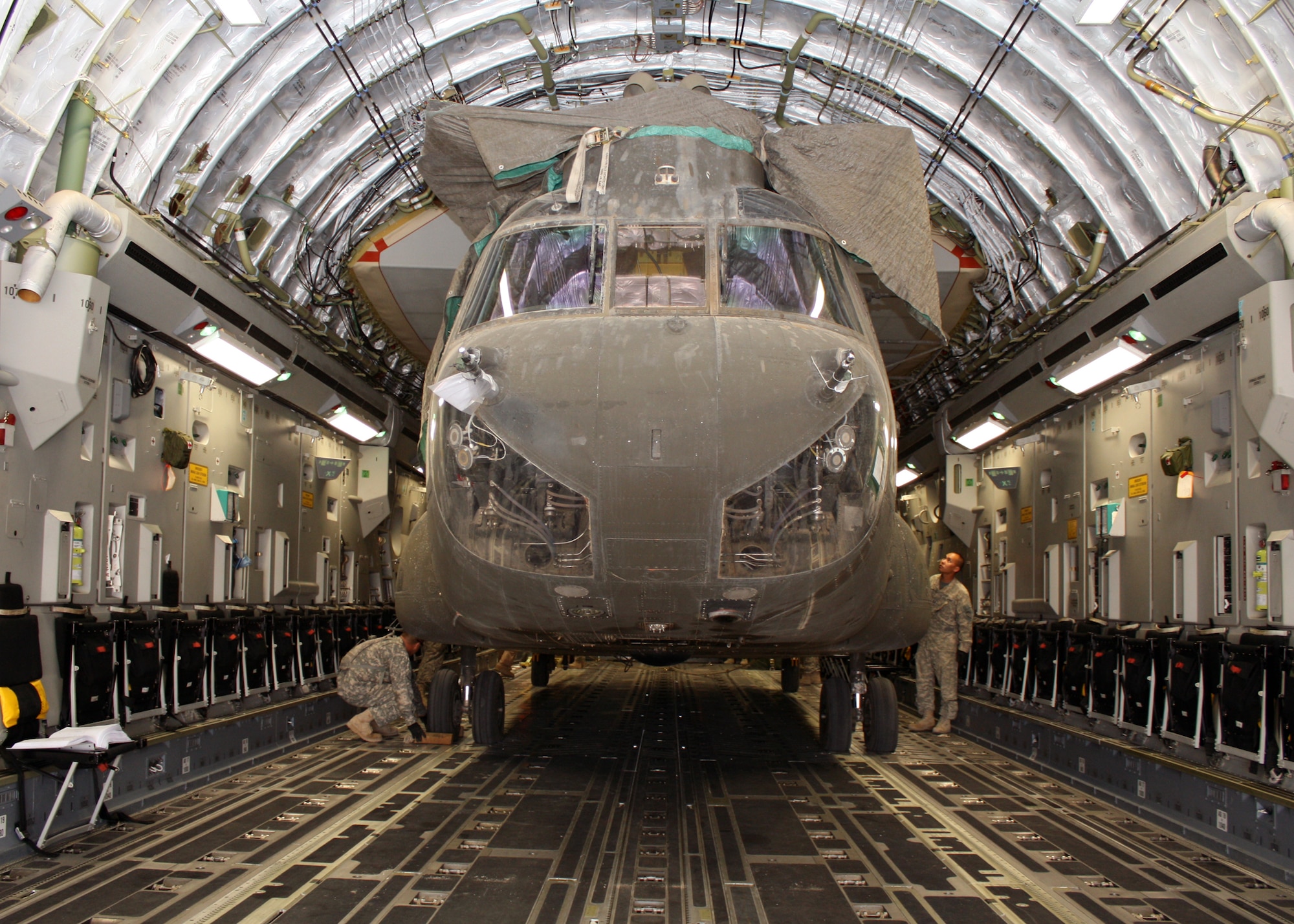 Army Capt. Stephen Lee inspects an Army CH-47 Chinook helicopter after it is loaded into a C-17 Globemaster III July 13, 2010, at Joint Base Balad, Iraq. Ensuring the helicopter stays in place during travel is crucial for both the aircraft's safety and those onboard. Captain Lee is the 209th Aviation Support Battalion strategic air load officer in charge. (U.S. Air Force photo/Staff Sgt. Stacy Fowler)