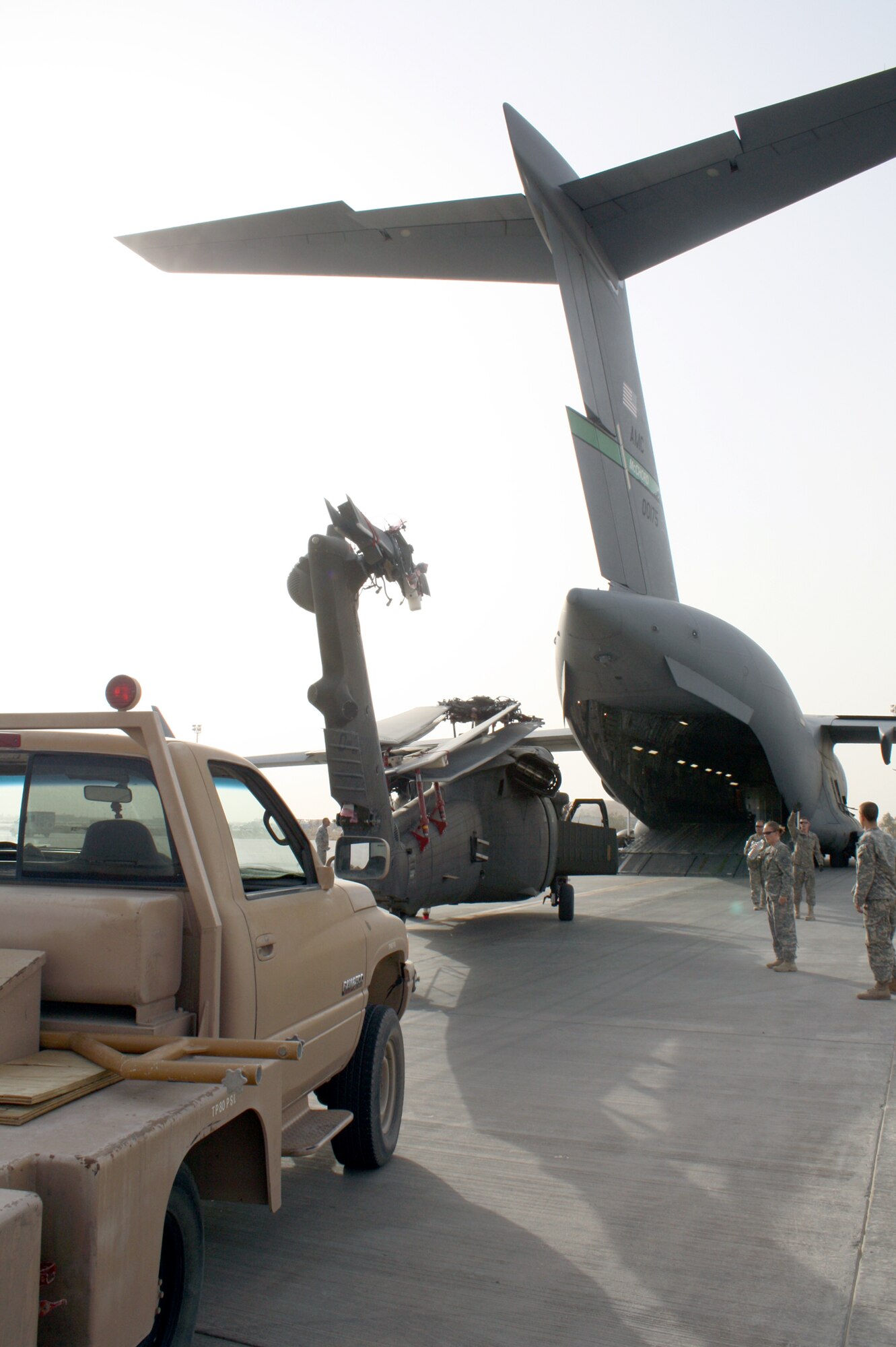 An Army UH-60 Blackhawk helicopter is loaded onto a waiting C-17 Globemaster III for transport to locations in areas of higher priority July 12, 2010, at Joint Base Balad, Iraq. Approximately 70 helicopters have transitioned through JB Balad for redeployment of U.S. forces from Iraq. (U.S. Air Force photo/Staff Sgt. Stacy Fowler)