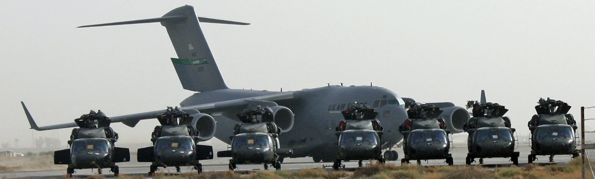 A C-17 Globemaster III pulls onto the parking ramp behind Army UH-60 Blackhawk helicopters waiting for transport July 12, 2010, at Joint Base Balad, Iraq. As the drawdown and redeployment of assets continues in Iraq, helicopters from bases in Northern Iraq have made their way to JB Balad to be inspected, prepped and shipped to new operating locations. (U.S. Air Force photo/Staff Sgt. Stacy Fowler)