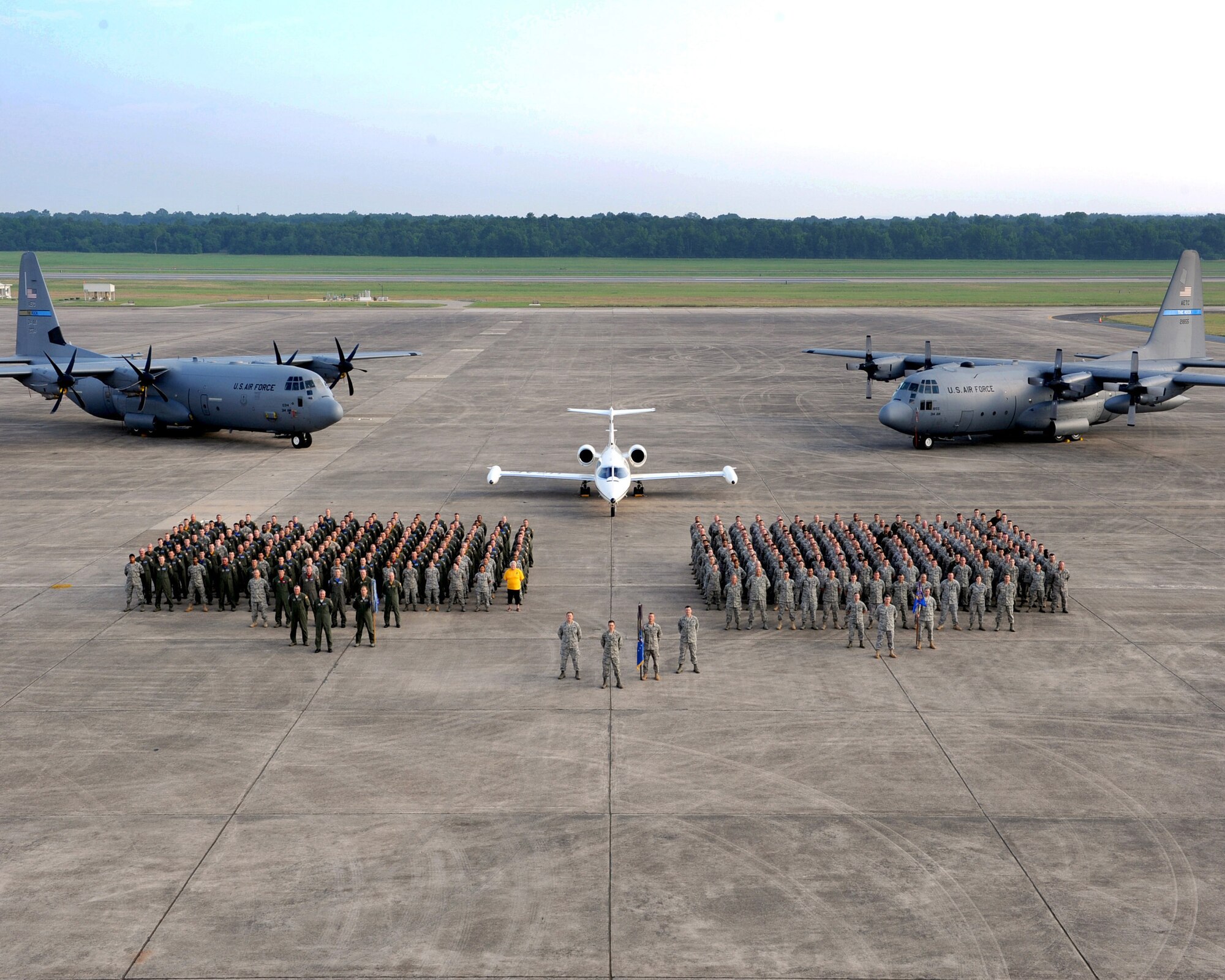 Nearly 350 military and civilian personnel from the 314th Airlift Wing stood in formation together in front of a C-130J, C-21 and C-130E for the wing’s annual group photo. (U.S. Air Force photo by Senior Airman Ethan Morgan)