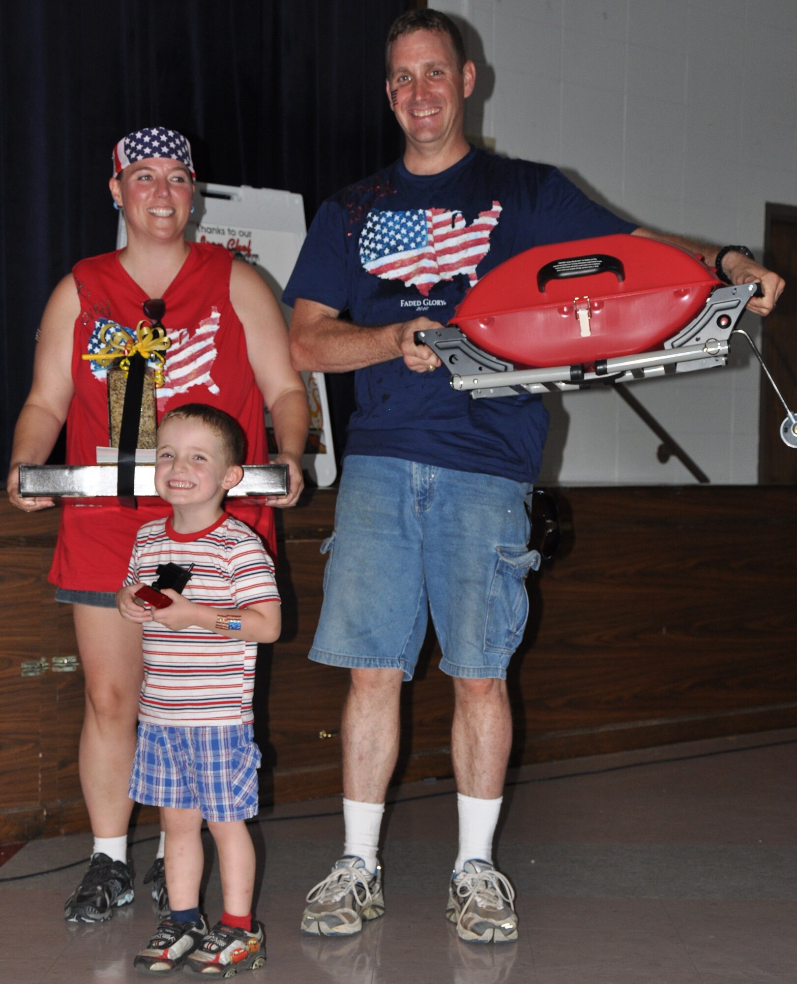 Stacey Dupre (left), Conner Dupre (center) and Petty Officer 1st Class Gerald Dupre of the Patriotic Pals team take home the grand prize after they won the inaugural Sheppard Iron Chef competition in the Community Center at Sheppard Air Force Base, Texas, July 17.  The inaugural Sheppard Iron Chef competition featured eight teams that had one hour to prepare an appetizer, main dish and dessert to be judged for presentation, taste and other criteria.  (U.S. Air Force photo/Tech. Sgt. Vernon Cunningham)