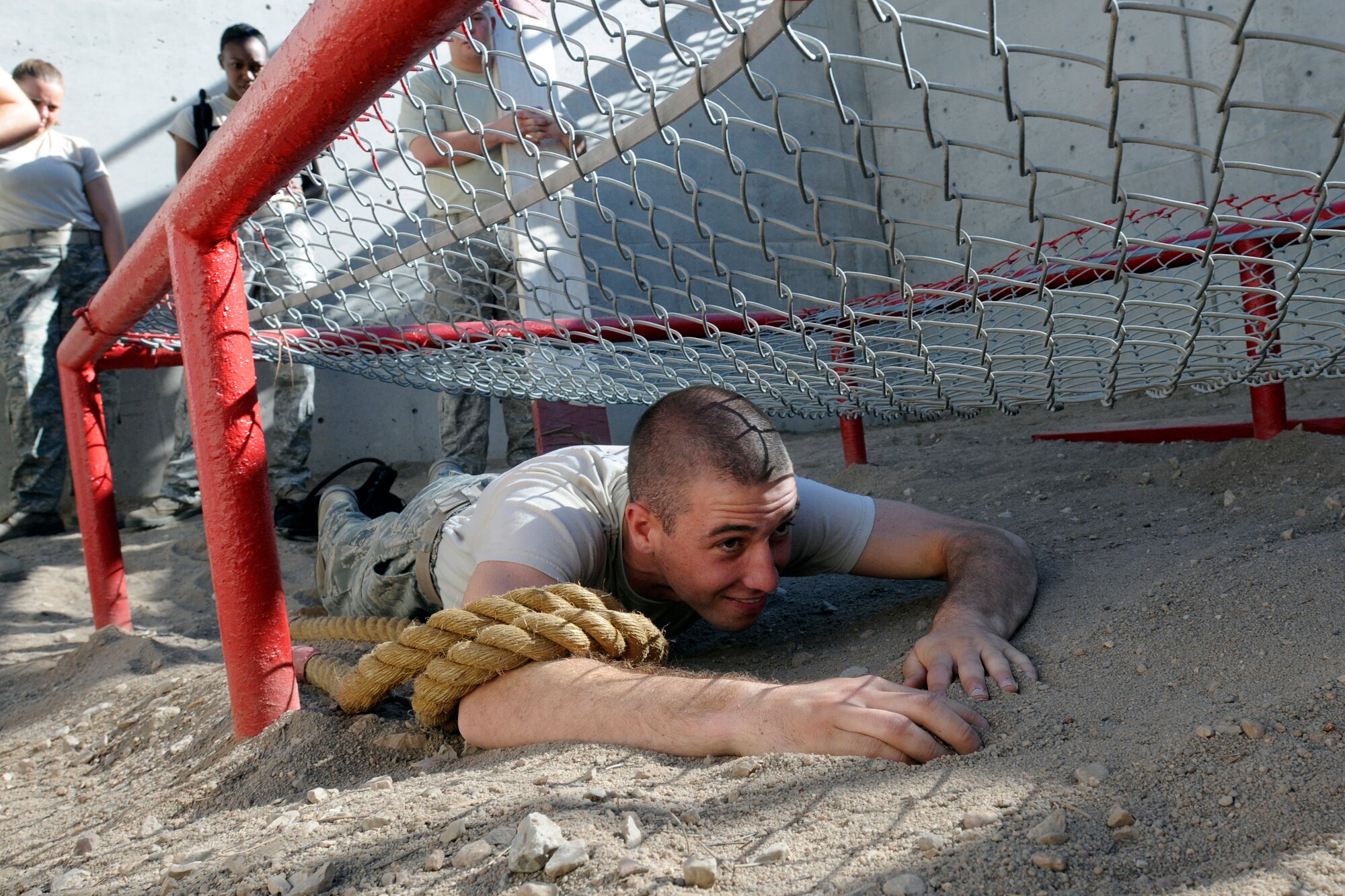 Basic Cadet Alexander Pecci III crawls through an obstacle at the Leadership Reaction Course in Jacks Valley during Basic Cadet Training at the U.S. Air Force Academy July 16, 2010. The Leadership Reaction Course teaches basic cadets group and individual problem solving and effective leadership by having them work through 15 obstacles of varying difficulty. (U.S. Air Force photo/J. Rachel Spencer)