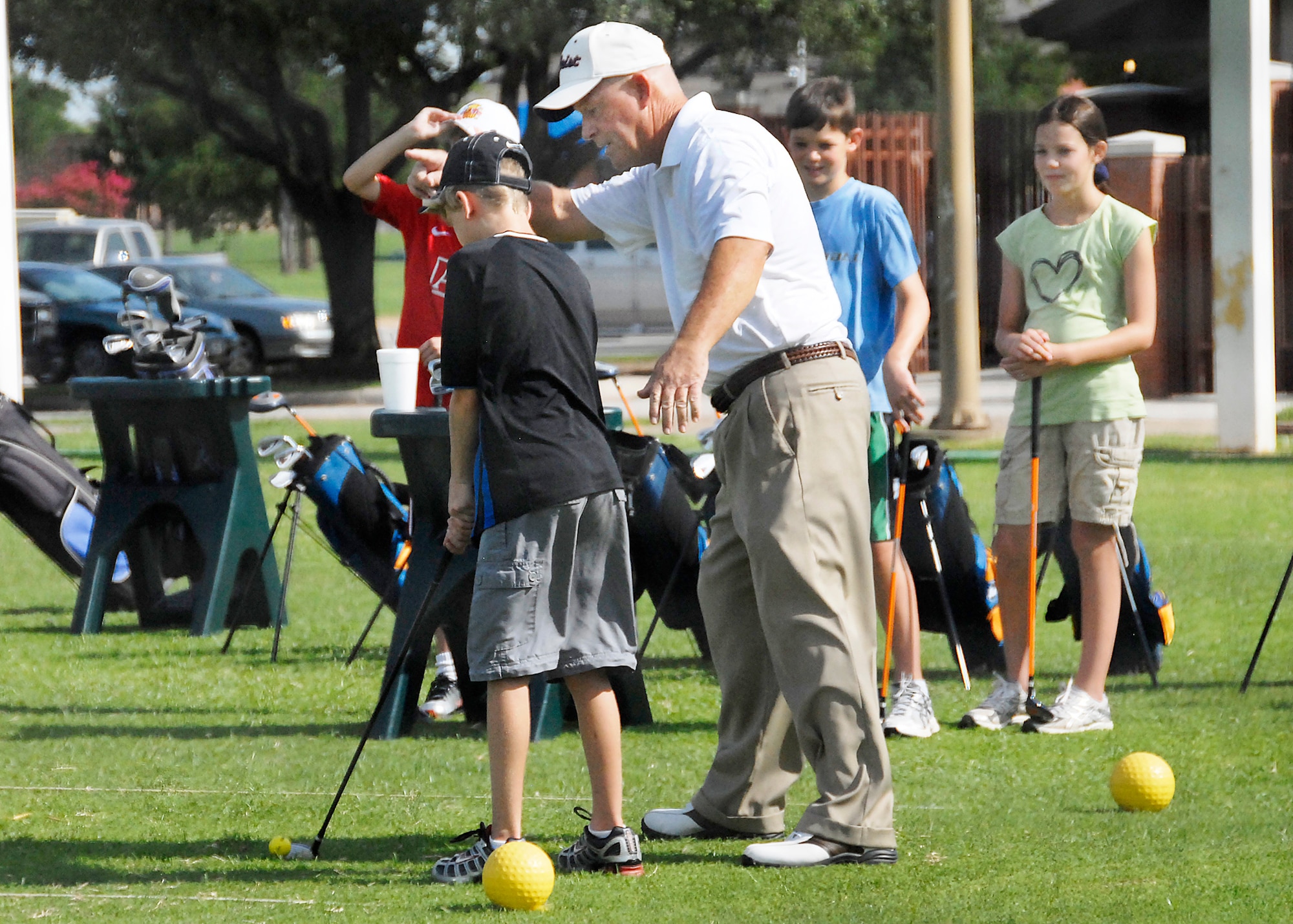 An instructor gives advice to a young golfer July 15 during a junior golf camp at Wind Creek Golf Course on Sheppard Air Force Base. The course hosted the one-week camp that included dependent children from military and civil service familes, as well as children from the surrounding area. (U.S. Air Force photo/Harry Tonemah)