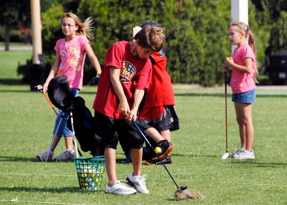 A young golfer digs out a ball July 15 during a junior golfer camp at Wind Creek Golf Course on Sheppard Air Force Base. The base hosts camps and lessons for young and seasons golfers. (U.S. Air Force photo/Harry Tonemah)