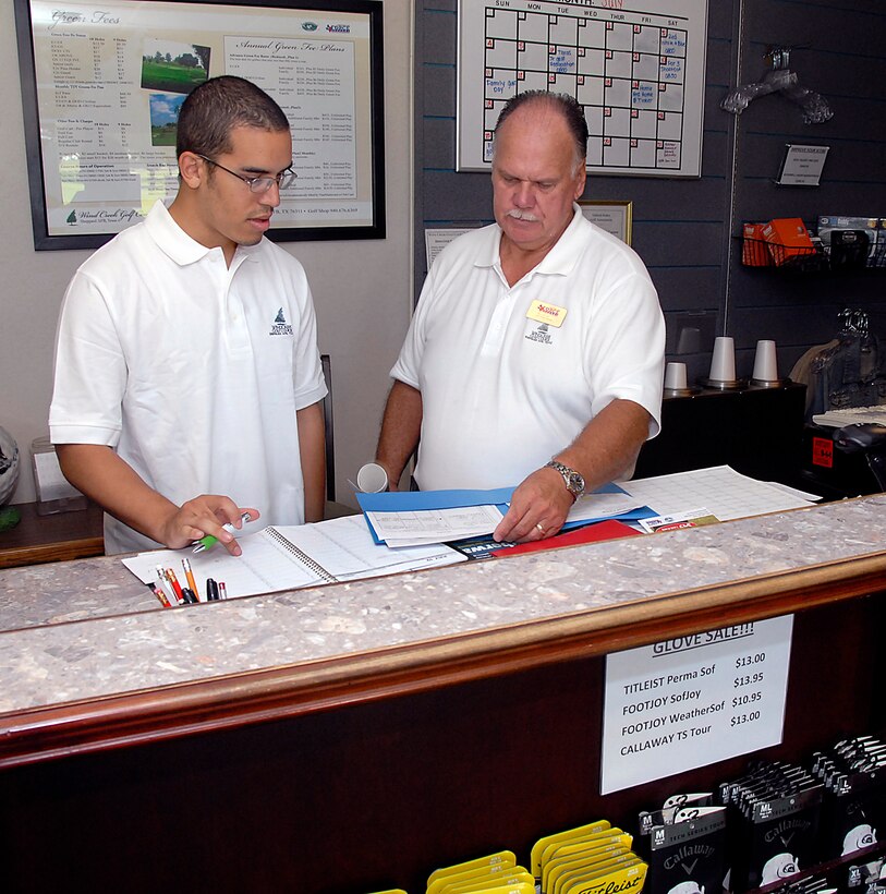 Paul Peters (right), the new manager for Wind Creek Golf Course at Sheppard Air Force Base, talks to sales clerk Doninique Lamar July 15 at the course's Pro Shop. The golf course has seen a decrease in the number of players visiting the course, but Mr. Peters said he is looking to turn that trend around with better playing surfaces and the offer of a round of golf for $20, including green fees and a gas-powered cart, seven days a week. (U.S. Air Force photo/Harry Tonemah)