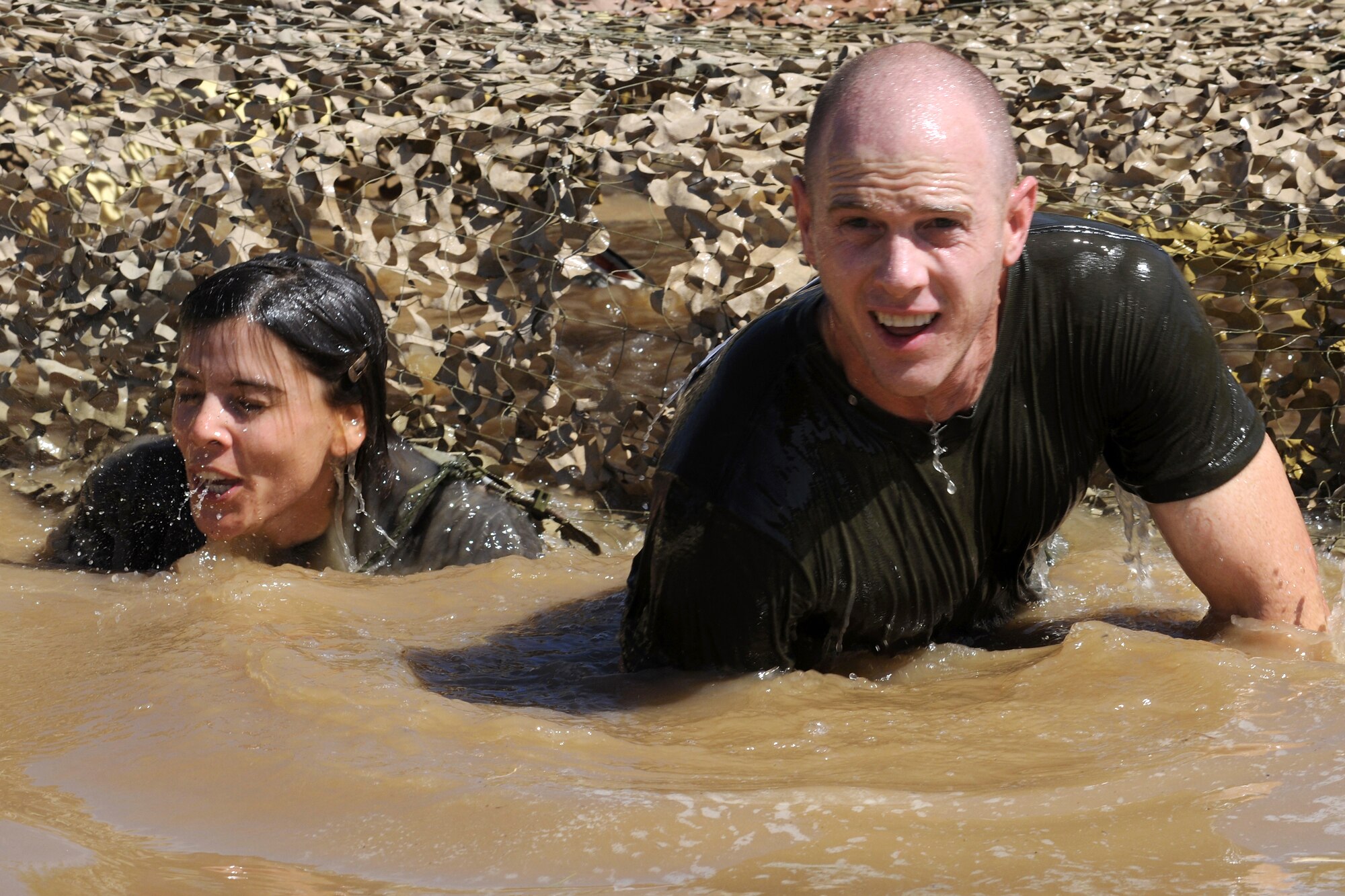 Airmen make their way through the mud pit during the 5K mud run at the Transit Center at Manas, Kyrgyzstan, July 11, 2010. Airmen took part in the course to help raise money for charity. (U.S. Air Force photo/Staff Sgt. Nathan Bevier)
