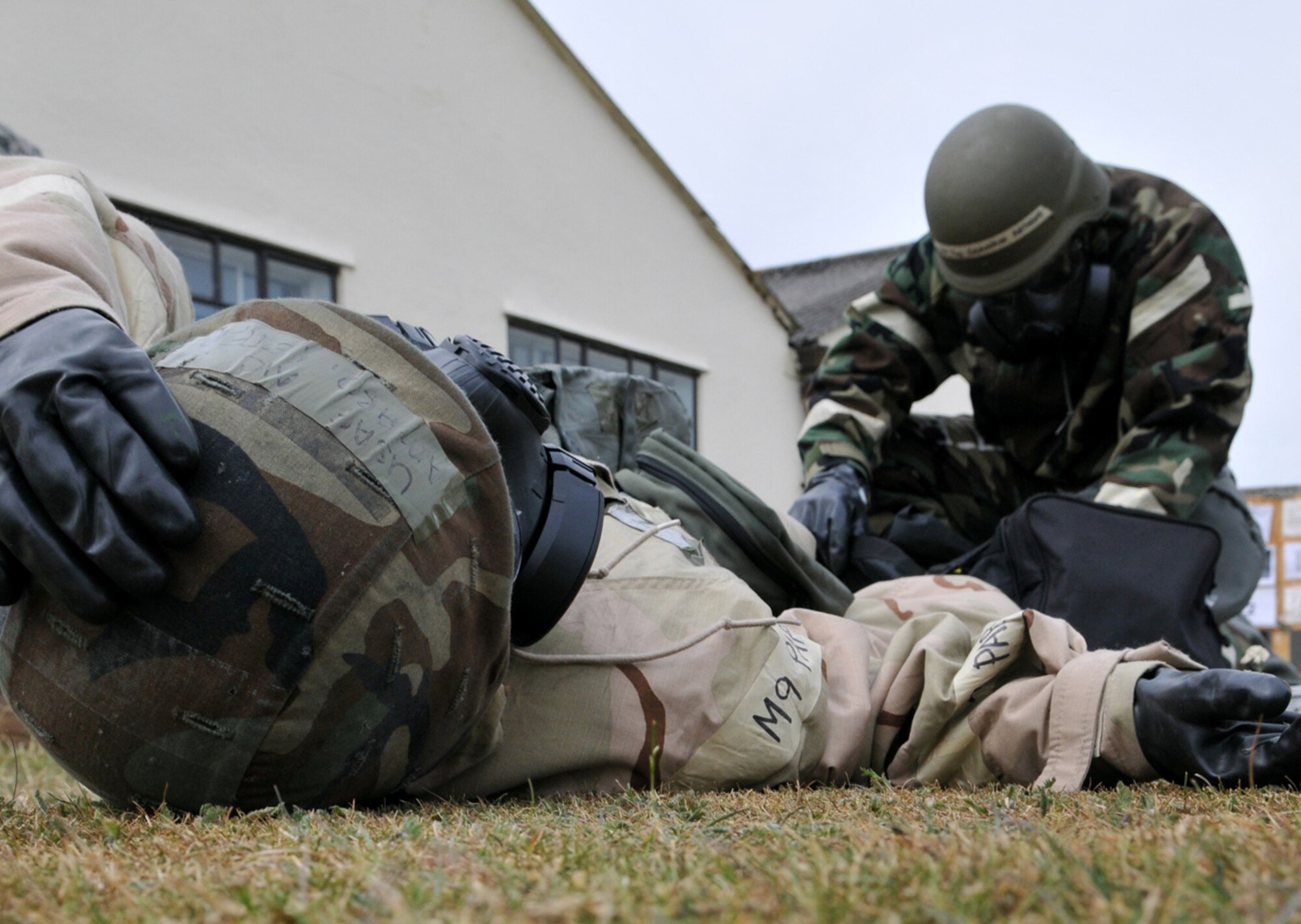 RAF MILDENHALL, England -- Tech. Sgt. Demarcus Anthony, 100th Logistics Readiness Squadron, begins treatment on a teammate who suffered a simulated shrapnel wound during an exercise July 20.  Sergeant Anthony was part of a team assigned to check the exterior of his building following a simulated attack during exercise Quick Bank 10-06.  (U.S. Air Force photo/Staff Sgt. Austin M. May)