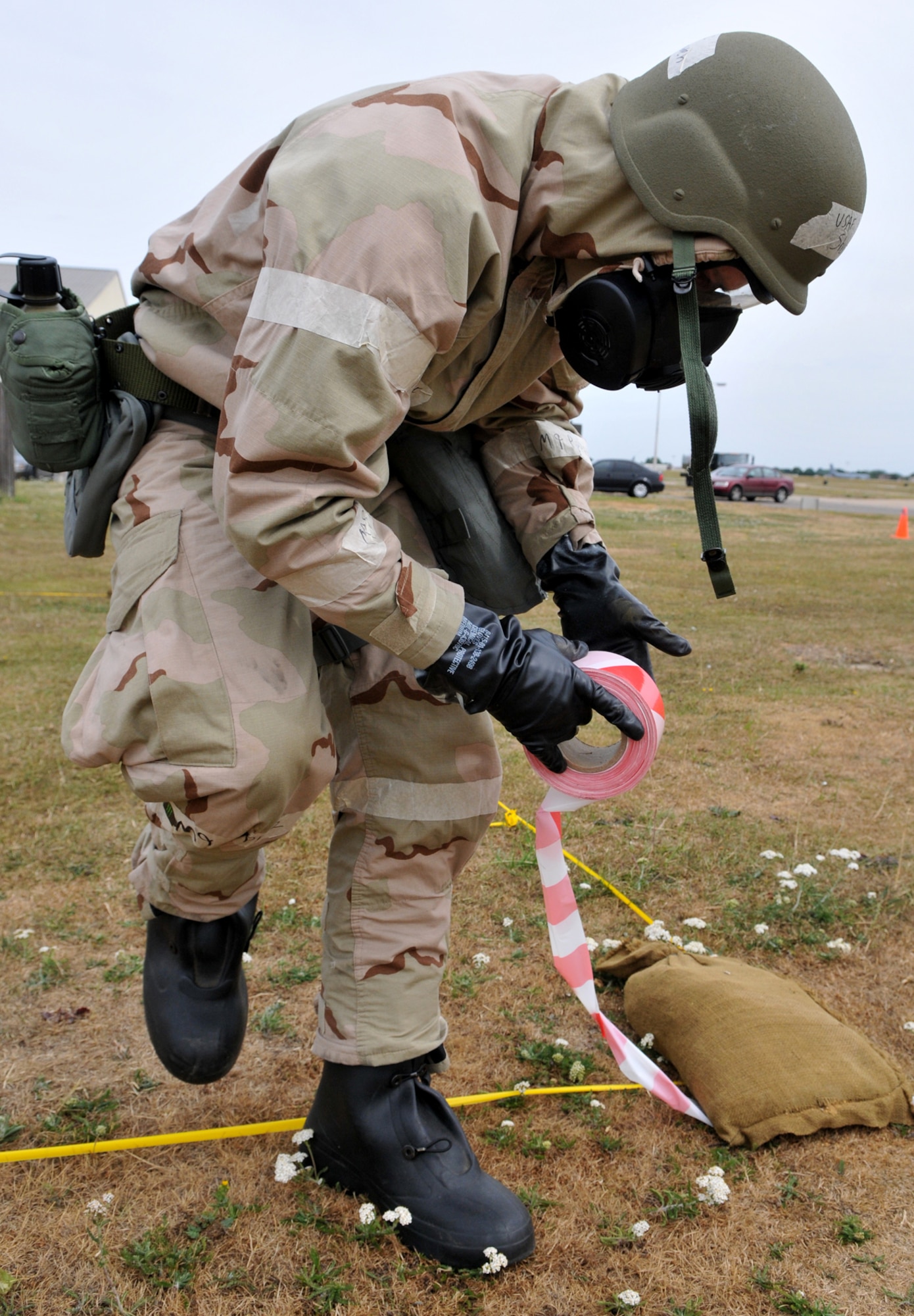 RAF MILDENHALL, England -- Airman 1st Class Shayn Bowen, 100th Logistics Readiness Squadron, ropes off a cordon around a piece of unexploded ordnance during an exercise July 20.  Exercise Evaluation Team members placed the dummy bomb to test the ability of Airmen participating in the exercise to locate and report hazards. (U.S. Air Force photo/Staff Sgt. Austin M. May)