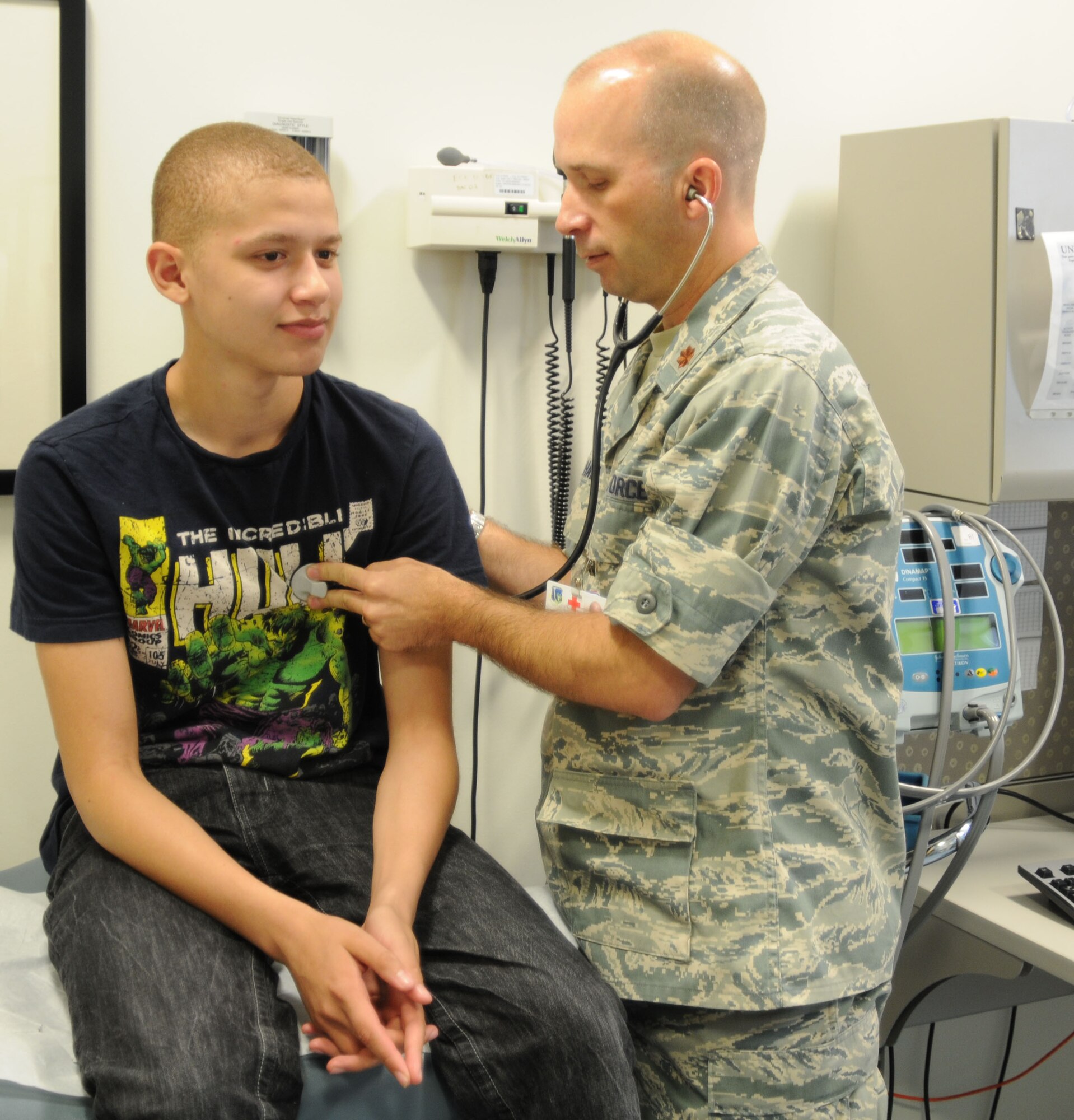 Dr. (Maj.) Gerald Hall, 48th Medical Operations Squadron Pediatrics Flight chief, checks Lakenheath High School student Darrell Johnson’s heart during his sports physical July 16. All students who attend Department of Defense schools overseas must receive a physical before attending class or playing a sport. (U.S. Air Force photo/Senior Airman David Dobrydney)