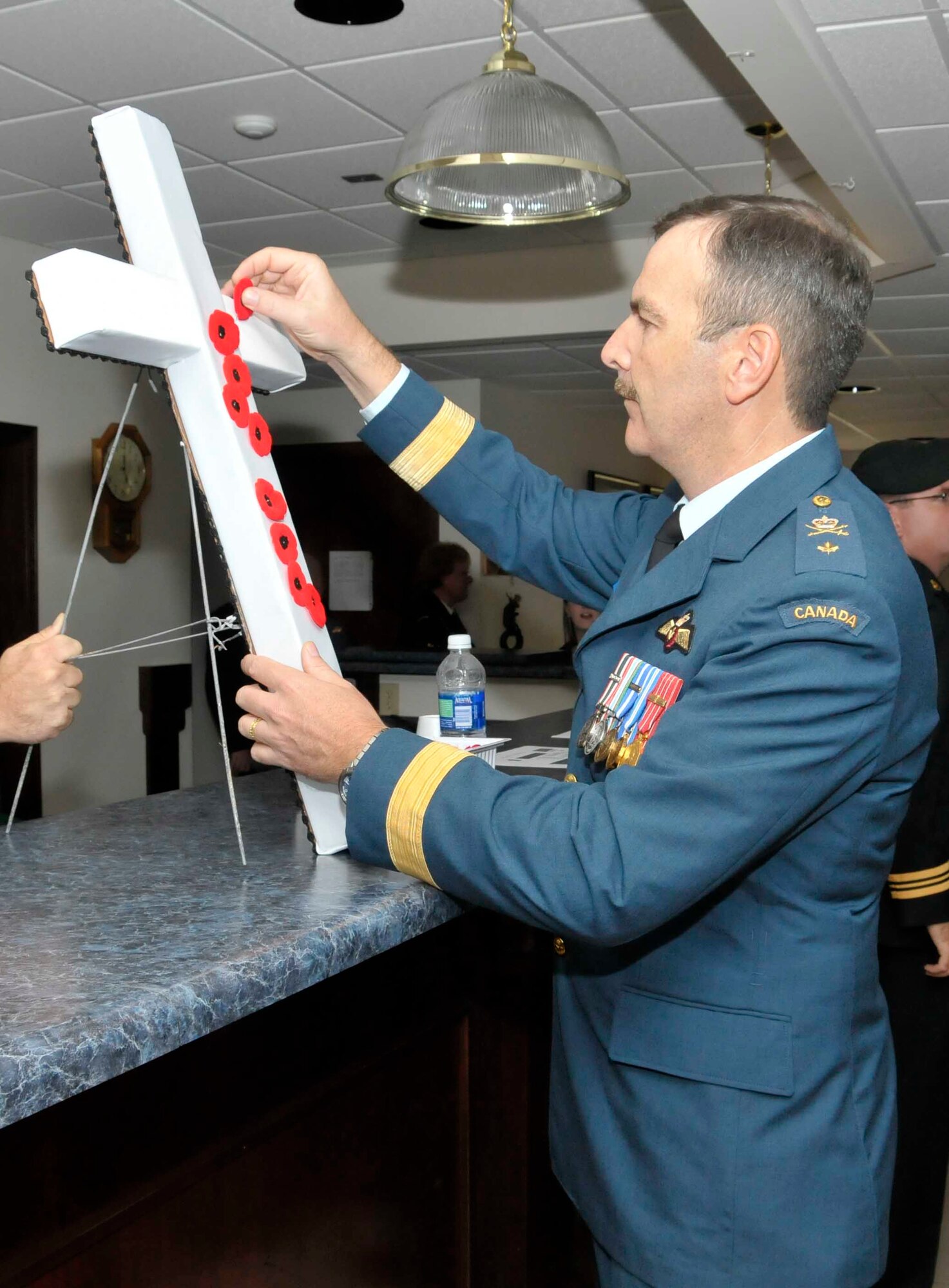 Continental U.S. NORAD Region deputy commander Brig. Gen. André Viens, Continental U.S. NORAD Region deputy commander, places a traditional poppy on a cross during Canadian Remembrance Day Nov. 11, 2009, commemorating the sacrifices of the members of the Armed Forces.  (U.S. Air Force photo)