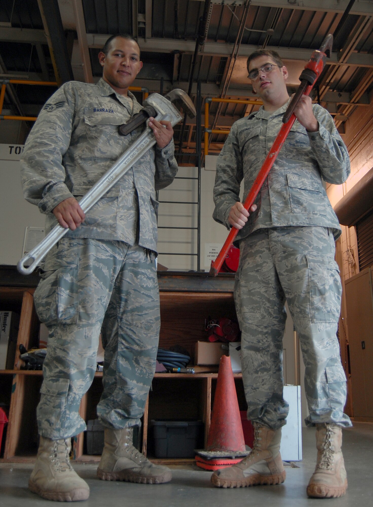 Senior Airman Richard Barraza (left) and Senior Airman James Founds, 43rd Civil Engineer Squadron plumbers, stand with tools in hand prior to going to a work site July 15. These Airmen are responsible for maintaining and repairing water delivery systems to every facility on Pope. (U.S. Air Force photo/Senior Airman Kris Levasseur)