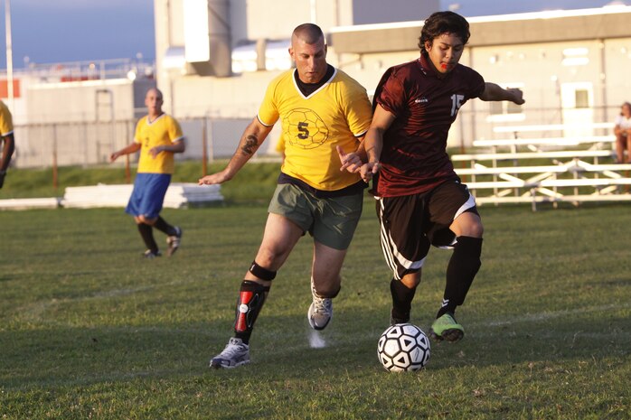 Andre Bugawan (right), forward position for Orient Tigers, attempts to overtake Lon Stedman (left), forward for Blood, Swear and Beer during an intramural soccer game at Penny Lake here July 20.