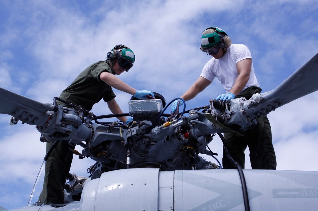 Seamen Ryan Seiz and Curtis Worrell, aviation electricians mates with Helicopter Sea Combat Squadron 25, use Mil-C-85570, a special chemical cleanser primarily used to clean naval aircraft, to swab the MH-60S Knighthawk they are responsible for maintaining. HSC-25’s primary missions are vertical replenishment and search and rescue. Additionally they provide vital logistical support during special operations.