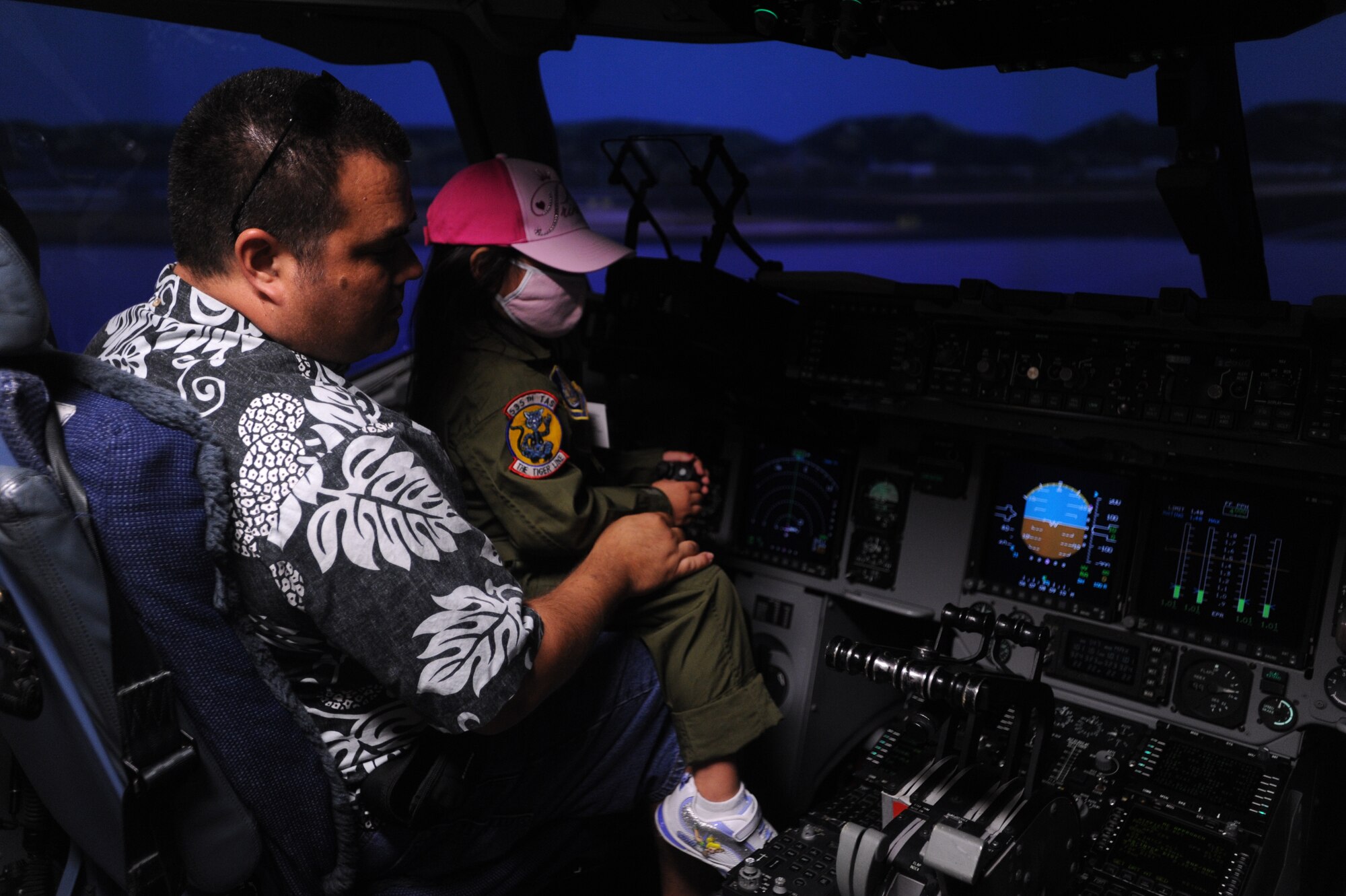 JOINT BASE PEARL HARBOR HICKAM, Hawaii - Kyra Furukawa, 5, flys a C-17 simulator during a tour as part of the Pilot for a Day Program held by the 535th Airlift Squadron here, July 16. Kyra is diagnosed with Juvenile Dermatomyositis and was chosen for the Pilot for a Day program by the Kapiolani Medical Center. (U.S. Air Force photo/Senior Airman Gustavo Gonzalez)