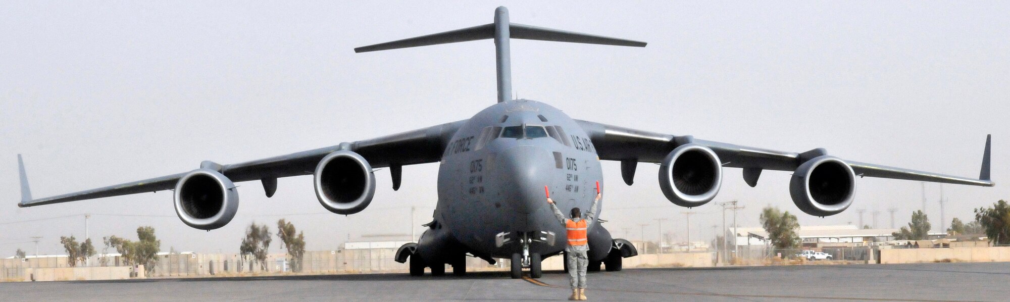 Airman 1st Class Robert Jacoby marshals a C-17 Globemaster III into its parking spot July 12, 2010, at Joint Base Balad, Iraq. Airman Jacoby is a 521st Air Mobility Operations Group, Det. 5 communication-navigation equipment maintainer. (U.S. Air Force photo/Staff Sgt. Phillip Butterfield) 