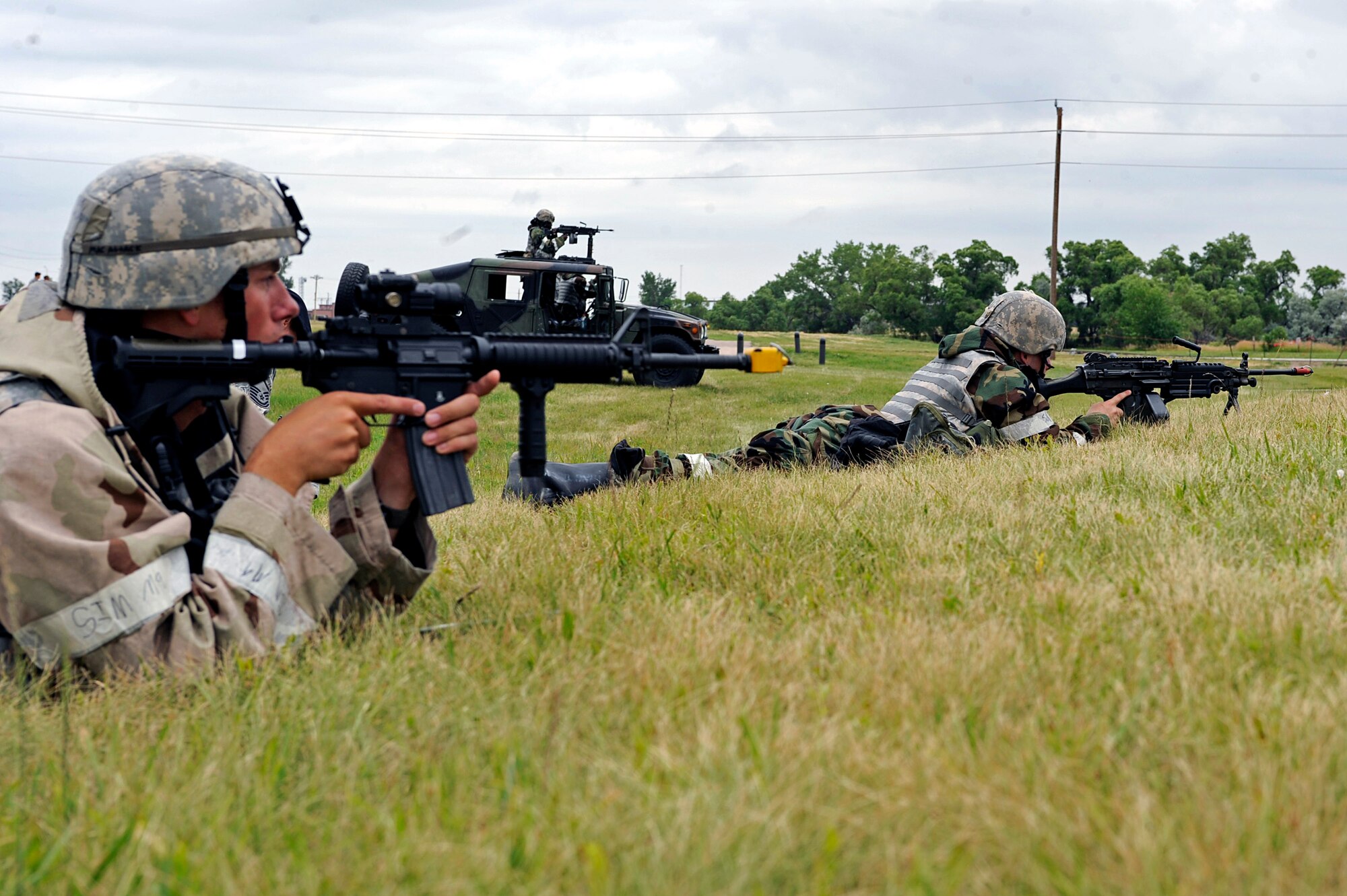 ELLSWORTH AIR FORCE BASE, S.D. – (Left) Airmen 1st Class Bryan McClellan and Jordon Powers, 28th Security Forces Squadron patrolmen, defend their position during a simulated ground attack of a phase II operational readiness exercise, July 21. The phase II ORE tested Airmen across the base on their ability to operate in a deployed environment. (U.S. Air Force photo/Airman 1st Class Matthew Flynn)