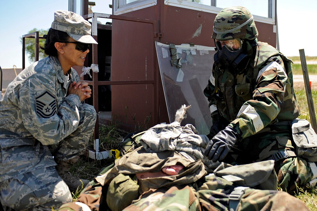 ELLSWORTH AIR FORCE BASE, S.D. – (Left) Master Sgt. Dianne Ramirez, 28th Medical Operations Squadron superintendant, overlooks self-aid buddy care provided to an exercise victim by Senior Airman Matthew Halvorson, 28th Civil Engineer Squadron structures journeyman, during a phase II operational readiness exercise, July 20. The phase II ORE is designed to test Airmen on operational readiness during a simulated deployment. (U.S. Air Force photo/Airman 1st Class Matthew Flynn)