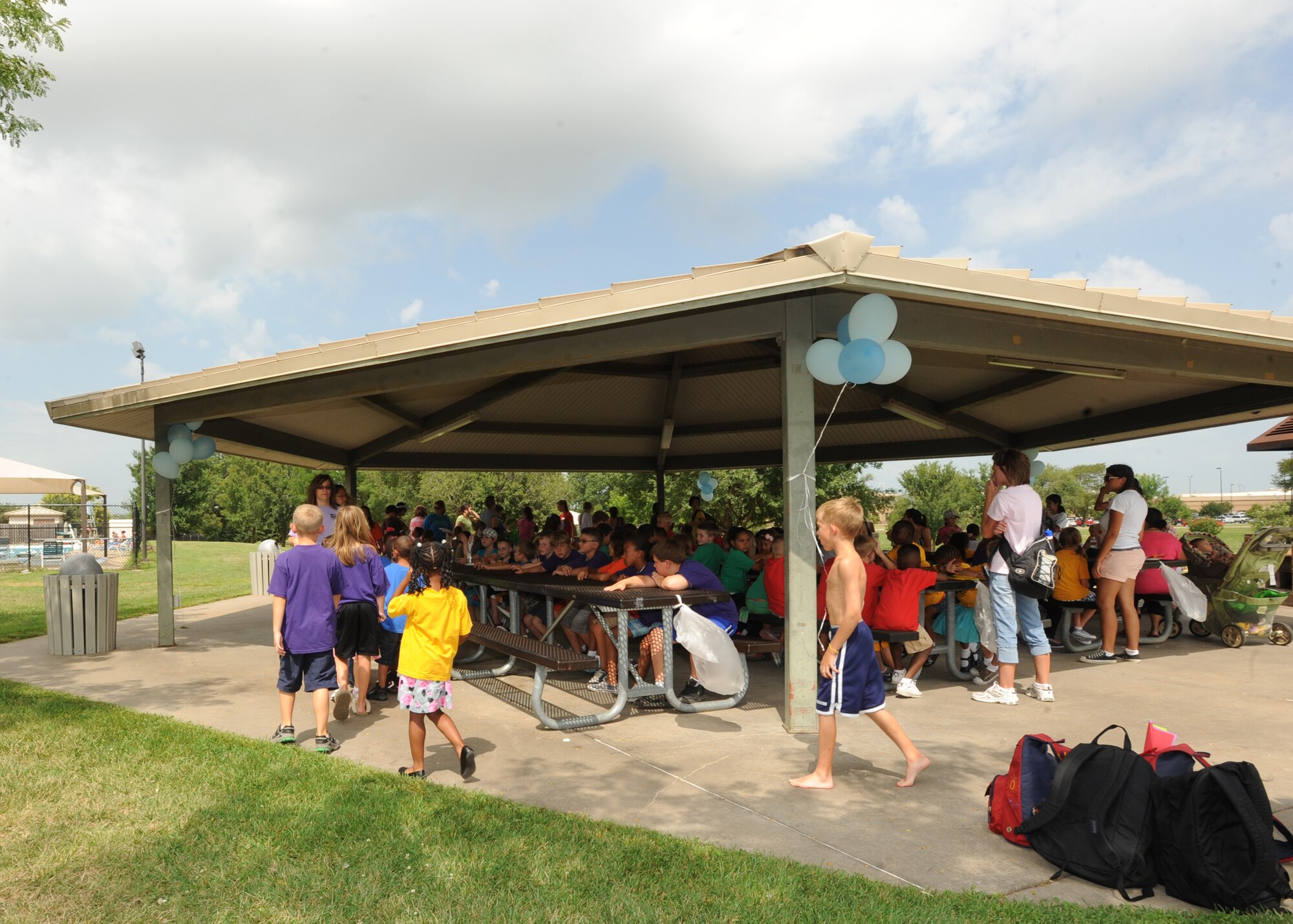 Children from McConnell’s summer reading program eat lunch at the pool pavilion, July 16, 2010, McConnell Air Force Base, Kan.  The luncheon was open to all summer reading program participants and their families. This event celebrated the completion of this year’s program theme, “Splashdown,” which encouraged children to read and cool-off during the months of June and July.   (U.S. Air Force photo/Airman 1st Class Andrea Salazar)