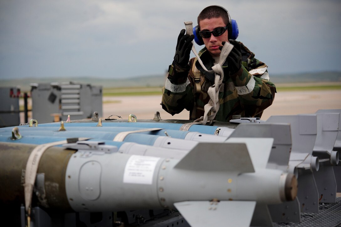 ELLSWORTH AIR FORCE BASE, S.D. – Airman 1st Class Alejandro Sanchez, 28th Munitions Squadron weapons loader, straps down guided bomb unit-38s during the phase II operational readiness exercise, July 21. The GBU-38 is a 500-pound bomb commonly used with the B-1B Lancer.  (U.S. Air Force photo/Airman 1st Class Corey Hook)