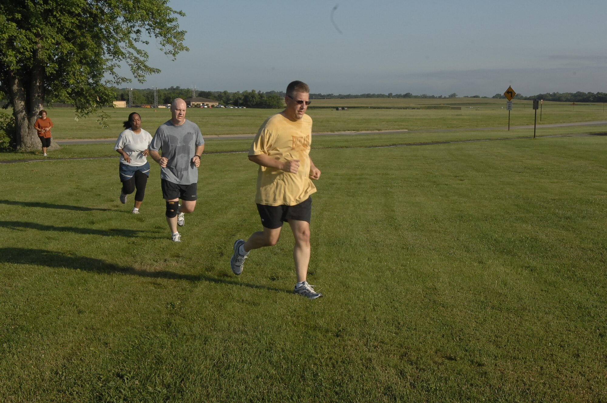 SCOTT AIR FORCE BASE, Ill. -- Participants from the Back-to-Basics class, led by Glendora Brock from the Fitness Center, run sprints in the field near the Honor Guard building. The class focuses on fitness but in a way that is not just push-ups, sit-ups and running.  The class performs exercises that help with improving the whole body. (U.S. Air Force Photo by Airman 1st Class Amber R. Kelly-Herard)