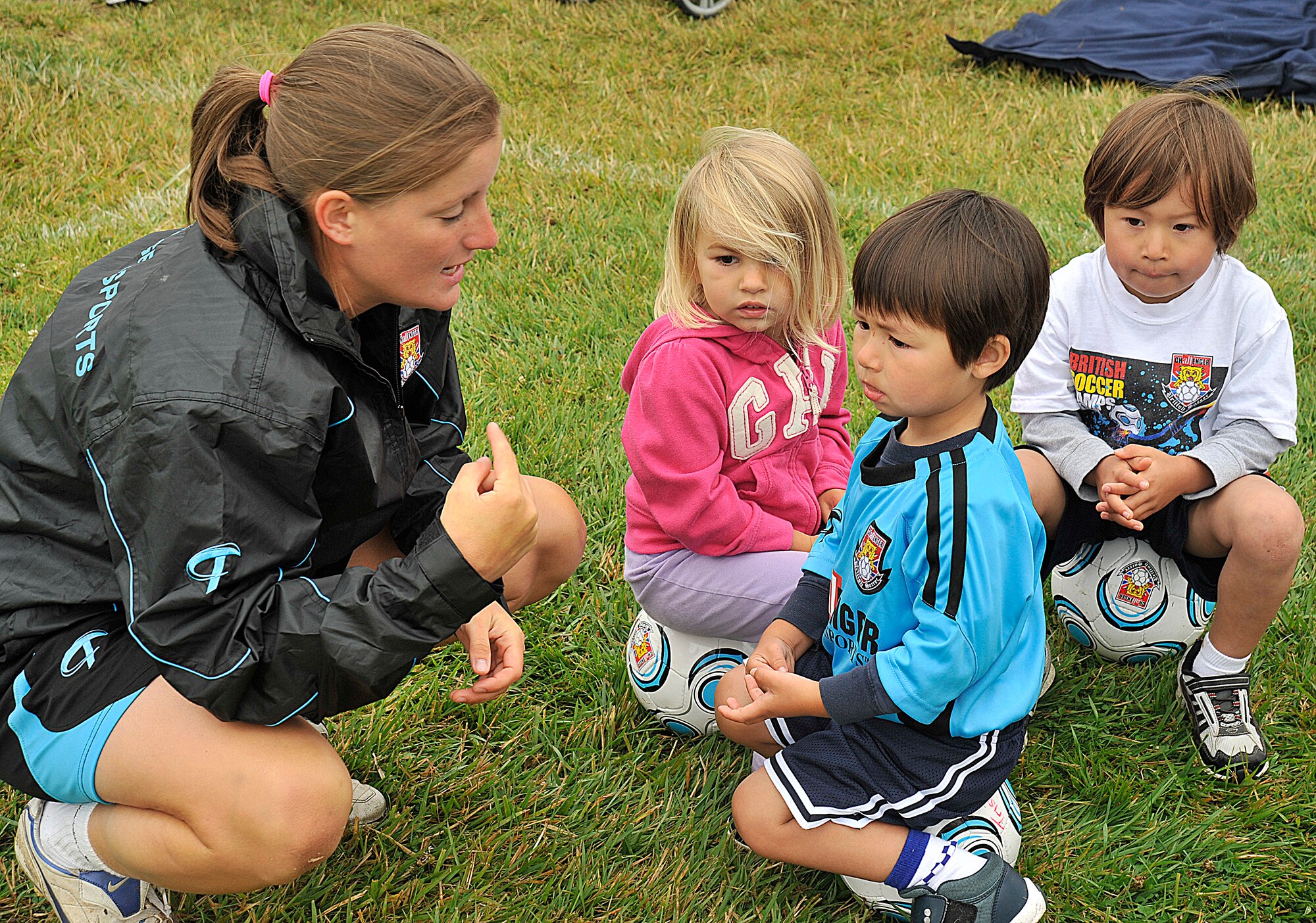 VANDNEBERG AIR FORCE BASE, Calif.--European coach Fern Burrage with Challenge Sports, explains to the children  how to play the game Alien Attack during soccer camp here, Tuesday July 20, 2010. The coaches use games such as Alien Attack and Spongebob to keep the children interested in learning the basic skills.  (U.S. Air Force Photo/Senior Airman Stephanie Longoria)