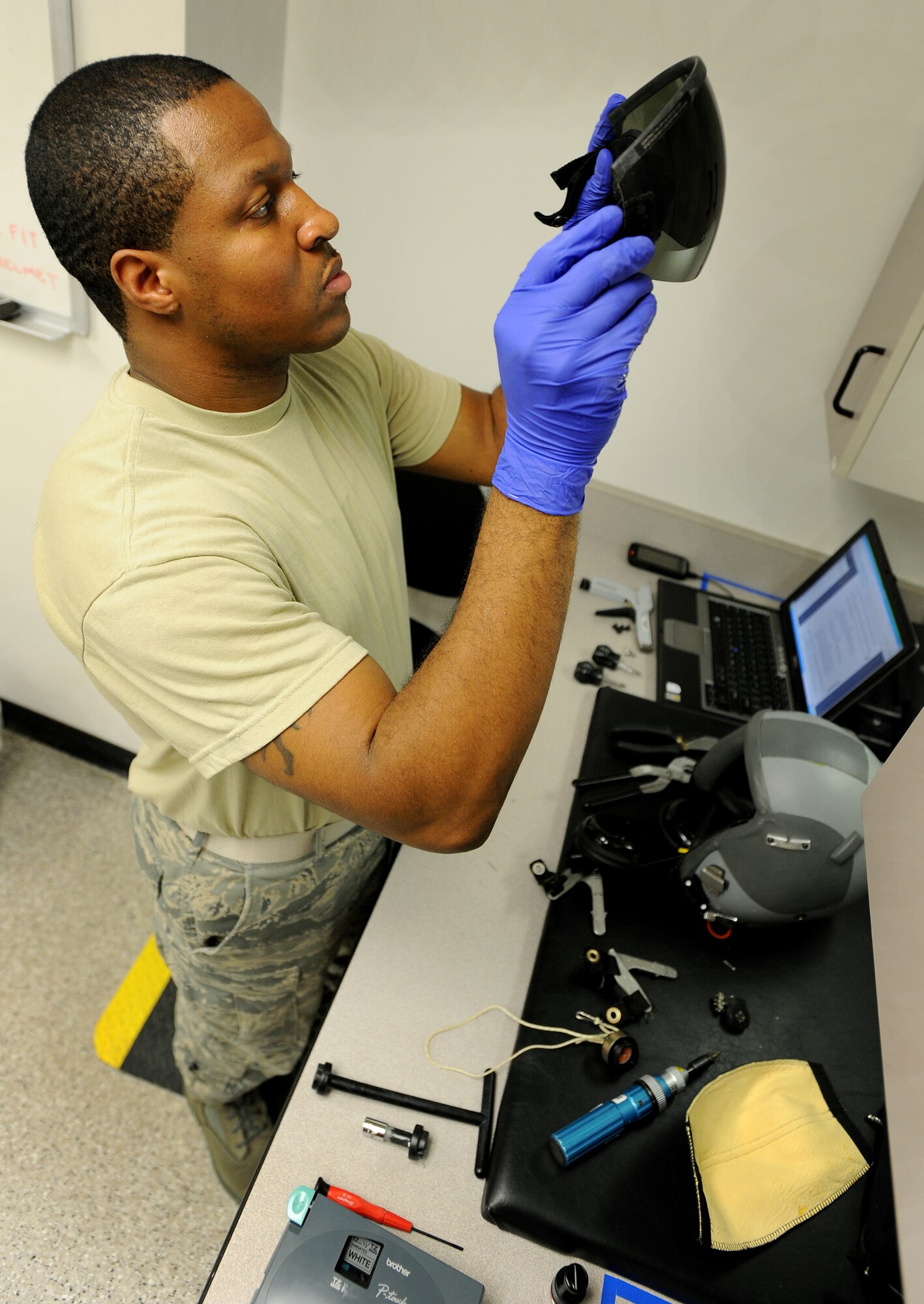 Airman 1st Class Lydell Carter, 22nd Operations Support Squadron aircrew flight equipment journeyman, performs an inspection July 20, 2010, McConnell Air Force Base, Kan. The Airmen check for any discrepancies that might affect a pilots breathing or communication function within the helmet.  McConnell performs a general inspection on more than 15 helmets daily in their more than 400 helmet inventory.  (U.S. Air Force photo/Senior Airman Courtney Witt)