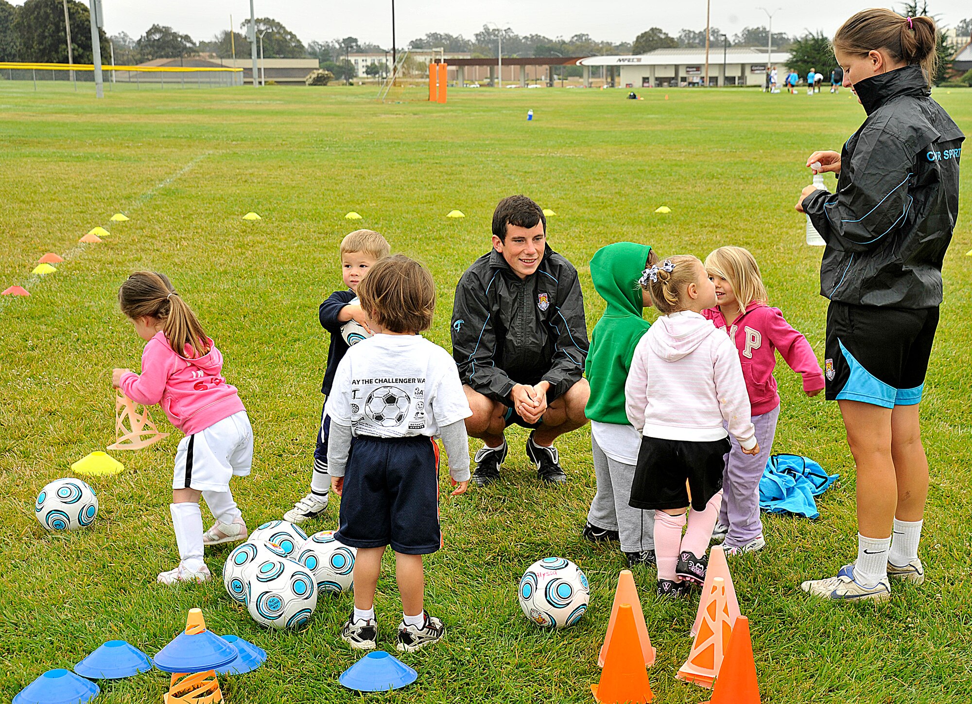 VANDNEBERG AIR FORCE BASE, Calif.--European coaches Fern Burrage and David Devlin with Challenge Sports, teach children basic soccer skills here, July 20, 2010.  The coaches incorporate games into the soccer camp to keep the children interested. (U.S. Air Force Photo/Senior Airman Stephanie Longoria)