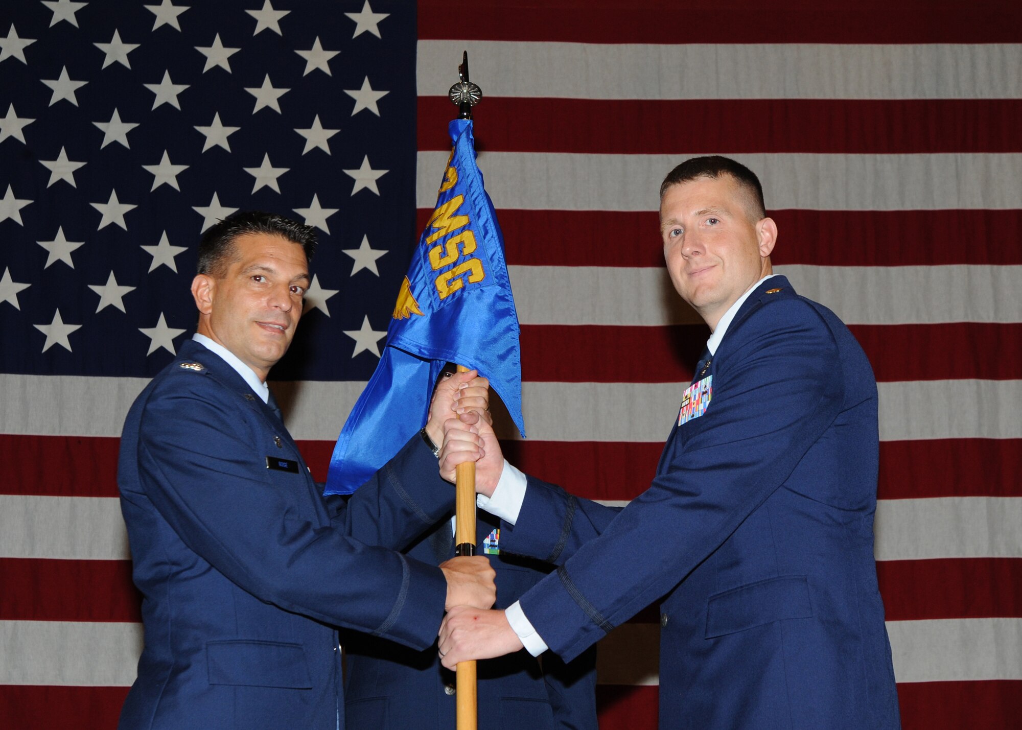 Col. Pat Rose, 22nd Mission Support Group commander, hands the guidon to Maj. Robert C. Schroeter, 22nd Communications Squadron commander, during a change of command ceremony July 15, 2010, McConnell Air Force Base, Kan.  The passing of the guidon symbolizes Major Schroeter assuming command from the outgoing 22nd CS commander, Lt. Col. Sean Robinson.  The 22nd CS enables mission success through command, control, communications and computer services.  (U.S. Air Force photo/Airman 1st Class Andrea Salazar)