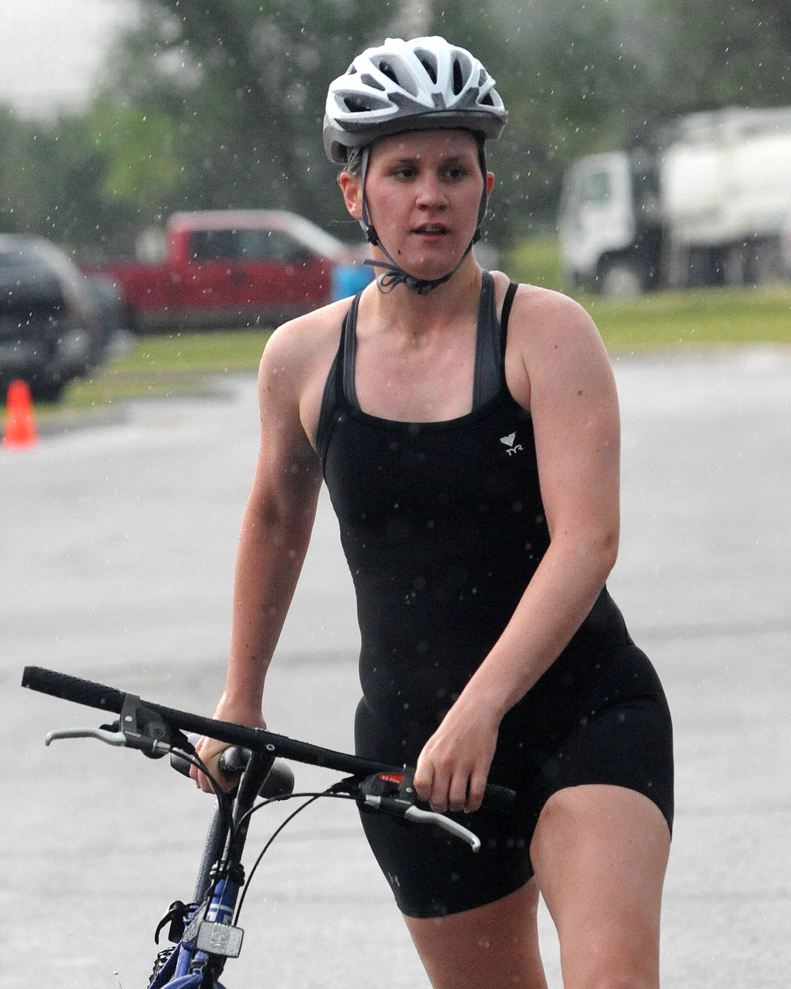 Kirsten Swenson walks her bike toward the running transition area July 17 during the 319th Air Refueling Wing’s 6th Annual Triathlon. Mrs. Swenson placed second in her age category with a time of 1 hour, 20 minutes and 53 seconds. (U.S. Air Force photo by Tech. Sgt. Johnny L. Saldivar)