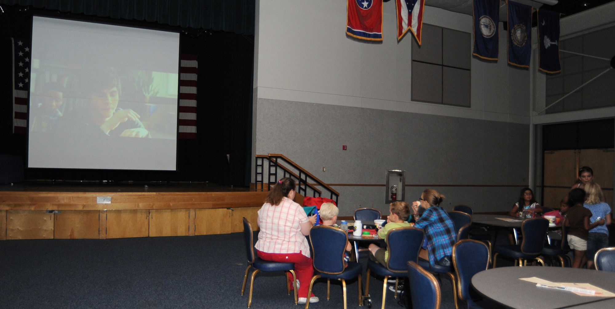 Team McConnell family members eat lunch and watch a movie during “Free Movie Monday” at the Robert J. Dole Community Center ballroom July 19, 2010, McConnell Air Force Base, Kan.  The movies have a parental guidance of PG or G and are geared for children currently on summer break from school.  The movies will be playing every Monday afternoon until Aug. 30.  (U.S. Air Force photo/ Senior Airman Maria Ruiz)