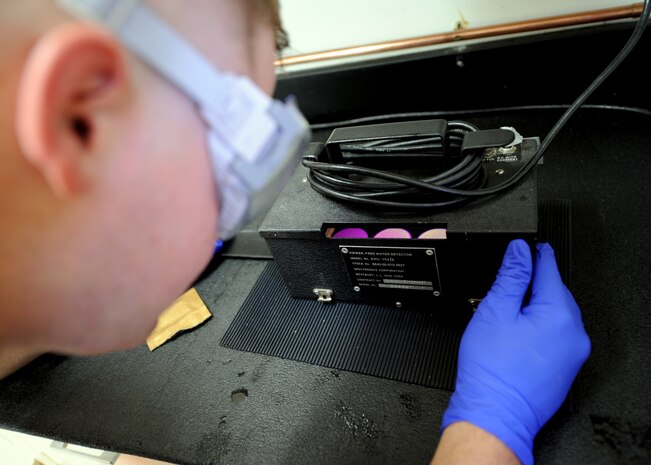 Staff Sgt. Mark Heitkamp runs an Aeronautical Engine Laboratory test on fuel samples July 20, 2010 on Joint Base Charleston, S.C. After running 300 milliliters of fuel through the AEL pad is then tested for water contents which will show up as neon green dots. Sergeant Heitkamp is the noncommisioned office in charge of the fuels laboratory with the 628th Logistics Readiness Squadron. (U.S. Air Force photo/Senior Airman Timothy Taylor)
