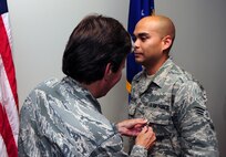 Senior Airman Jonathon Lovelady is presented the Joint Accommodation Medal by Col. Martha Meeker July 16, 2010, on Joint Base Charleston, S.C. Colonel Meeker is the commander of Joint Base Charleston. Airman Lovelady is a photographer with the 1st Combat Camera Squadron. (U.S. Air Force photo/Senior Airman Tyler Placie)