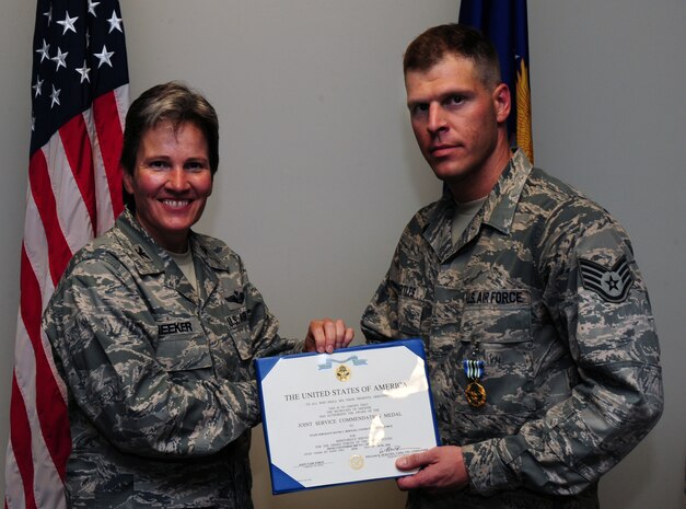 Staff Sgt. David Bertles is presented the Joint Accommodation Medal by Col. Martha Meeker. July 16, 2010 on Joint Base Charleston, S.C. Colonel Martha Meeker is the commander of Joint Base Charleston. Sergeant Bertles is a videographer with 1st Combat Camera Squadron. (U.S. Air Force photo/Senior Airman Tyler Placie)