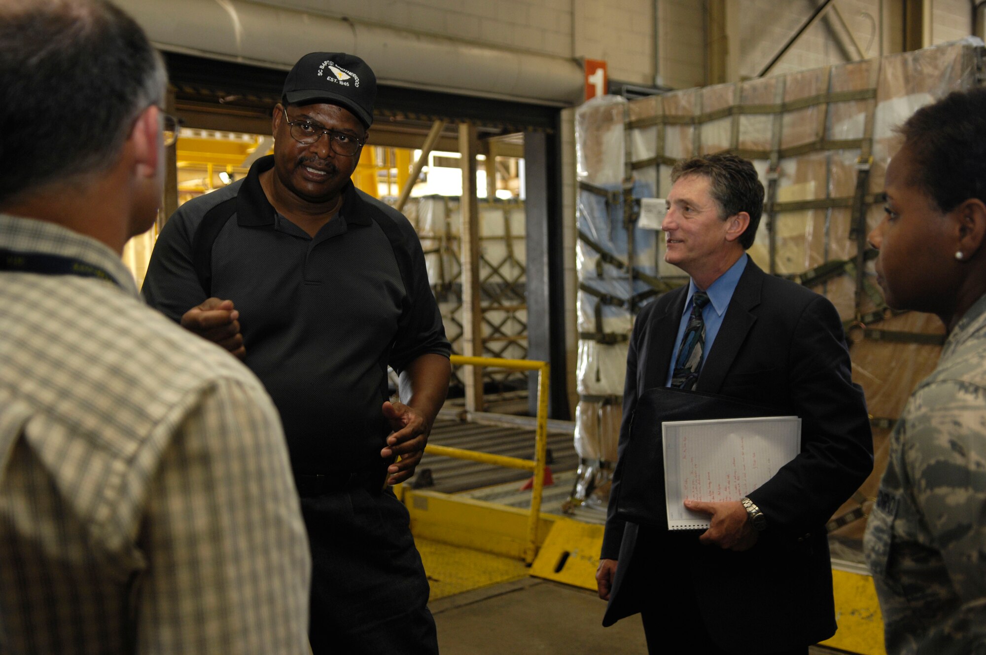 Bobby Robinson guides a group of scientists and engineers from the Air Force Research Laboratory  through the 437th Aerial Port Squadron July 16, 2010. The AFRL has many different programs which are all currently working on projects to improve deployed air base capabilities, safety and efficiency. Some of the departments within the AFRL include, energy systems, force protection, airfield pavements, fire research and robotics. Mr. Robinson is an air freight supervisor with the 437 APS. (U.S. Air Force Photo/Airman 1st Class Lauren Main)