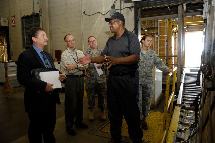 Bobby Robinson guides a group of scientists and engineers from the Air Force Research Laboratory  through the 437th Aerial Port Squadron July 16, 2010. The researchers visited Joint Base Charleston's APS to look for potential improvements that could be made to increase efficiency via robotics. One of the developing ideas which they have come up with is the "robo-pallet". The pallet is designed to be self-aware of the contents its moving and to be proficient enough to move itself and to know if any of its contents have been tampered with. Mr. Robinson is an air freight supervisor with the 437 APS. (U.S. Air Force Photo/Airman 1st Class Lauren Main)