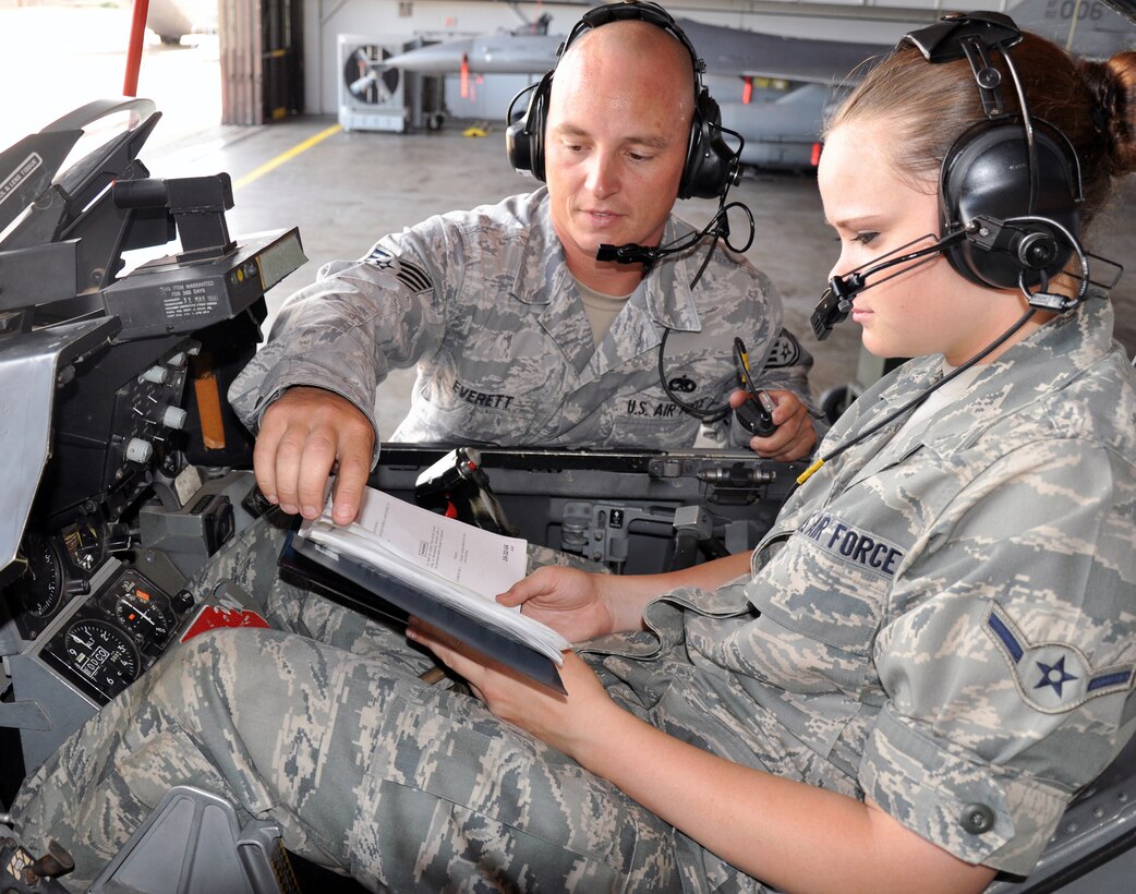 Tech. Sgt. Chad Everett (left) trains Airman Tiffany Watson on the use of a technical order during the F-16 Aircraft Maintenance Apprentice Course in Hangar 1040 at Sheppard Air Force Base, Texas, July 16. Sergeant Everett, 362nd Training Squadron F-16 mission readiness Airmen instructor, serves as one of 34 instructors who graduates about 750 students annually from the course.  (U.S. Air Force photo/Tech.Sgt. Vernon Cunningham)