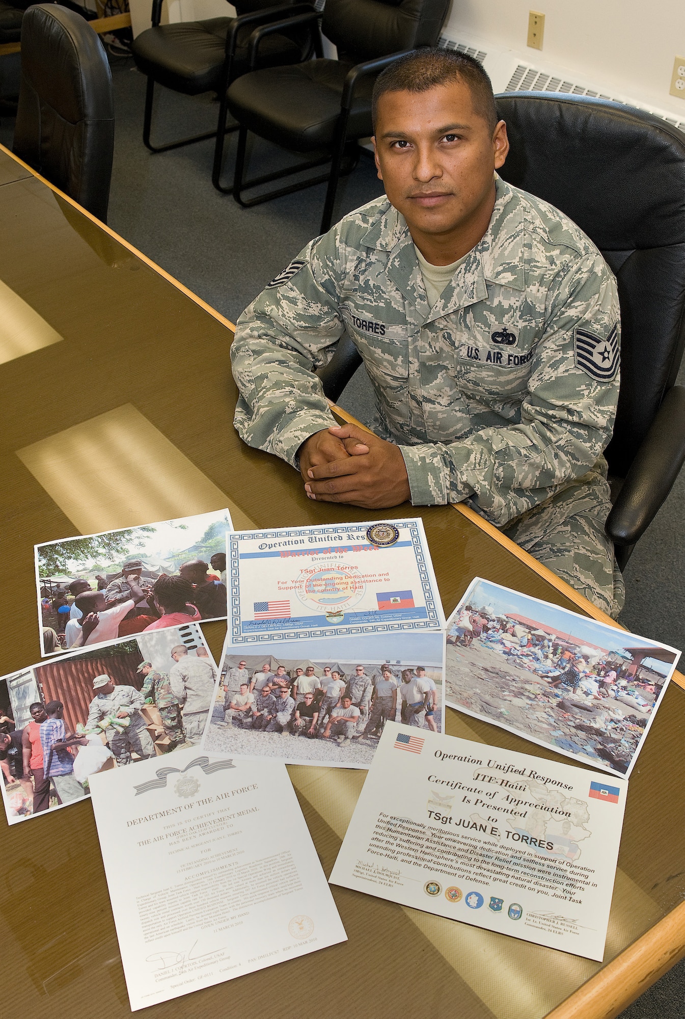 Technical Sergeant Juan Torres, 436th Logistic Readiness Squadron non-commissioned officer in charge of vehicle management and analysis, showcases his awards and some of his photos of Haiti July 20, 2010.  Sergeant Torres said his time in haiti taught him a true lesson in humility and a new found respect for what he has here at home, especially his children.  (U.S. Air Force photo by Jason Minto/released)
