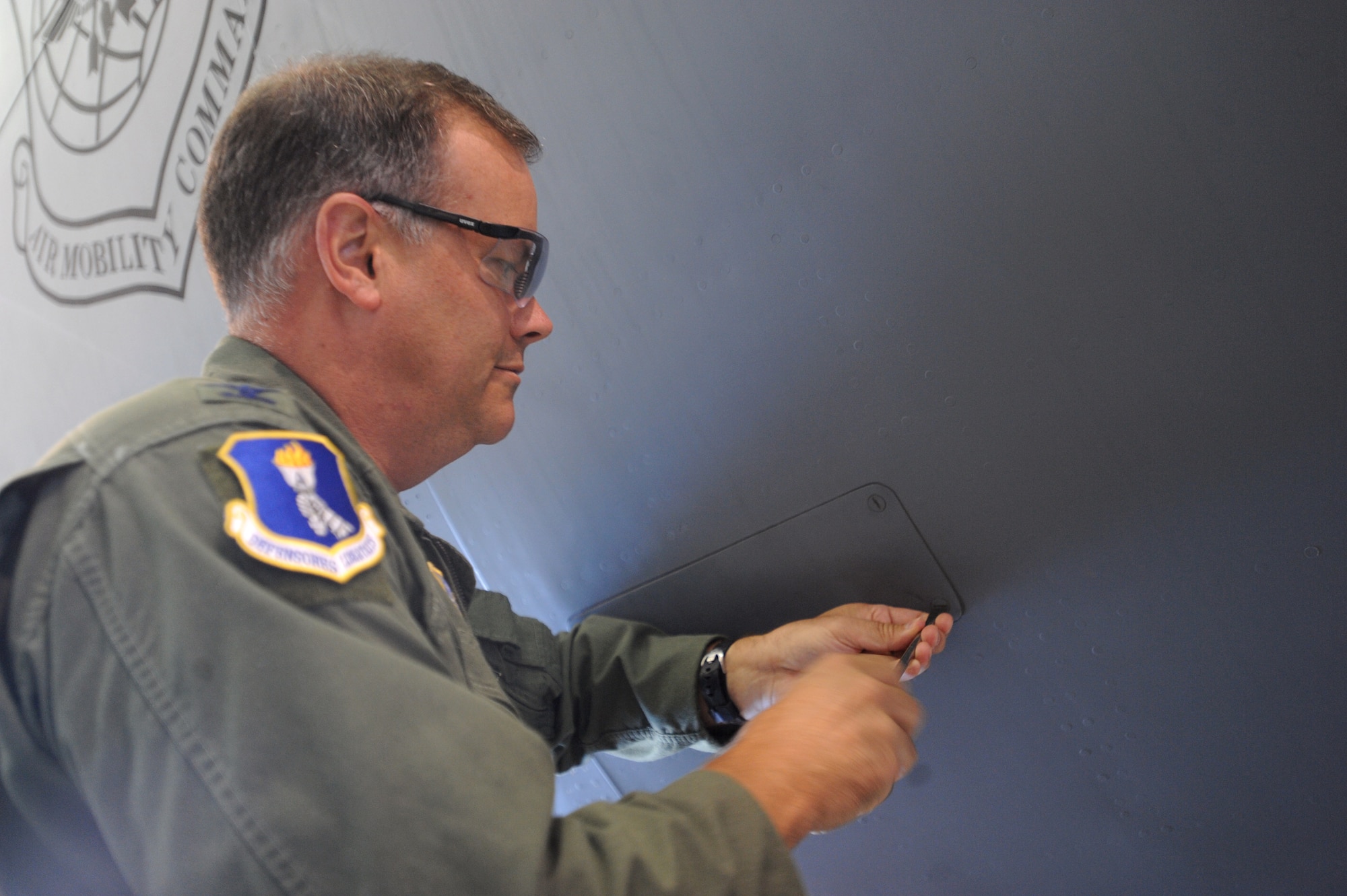 Col. Don Shaffer, 319th Air Refueling Wing commander, screws on the last panel of a KC-135 Stratotanker July 20 on Grand Forks Air Force Base, N.D., during a ceremony held to celebrate the completion of the final periodic isochronal inspection. More than 40 Airmen participated in the final PE/ISO. (U.S. Air Force photo by Staff Sgt. R. Michael Longoria)