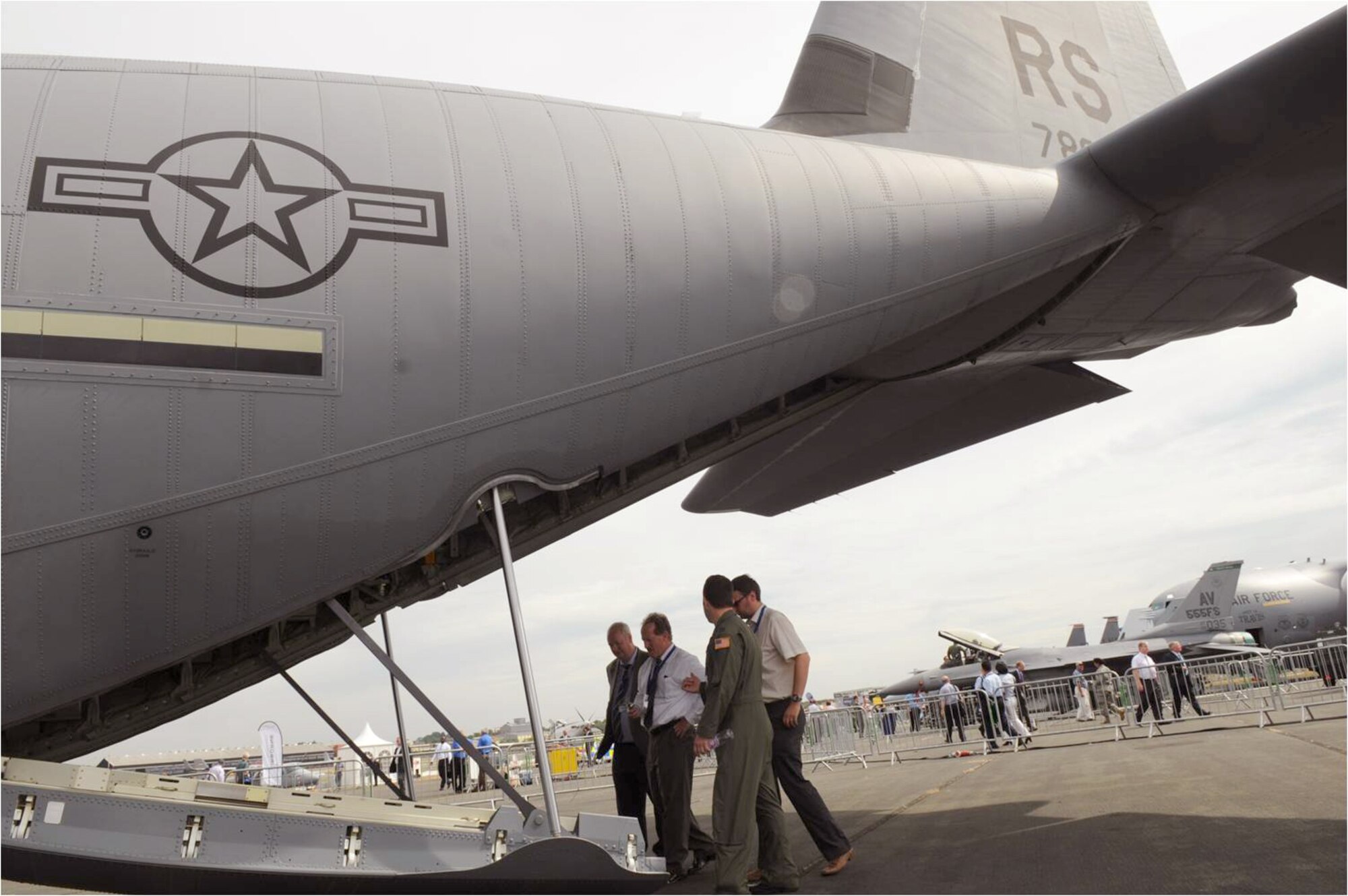 Capt. Samuel Bartrone escorts a group of spectators into the cargo bay of a C-130J Super Hercules at the 2010 Farnborough International Air Show July 20, 2010, in Farnborough, England. The air show takes place July 19 through 25, with approximately 1,300 exhibitors from private, commercial civil and military sectors. Captain Bartrone is a 37th Airlift Squadron pilot from Ramstein Air Base, Germany. (U.S. Air Force photo/Staff Sgt. Heather M. Norris) 