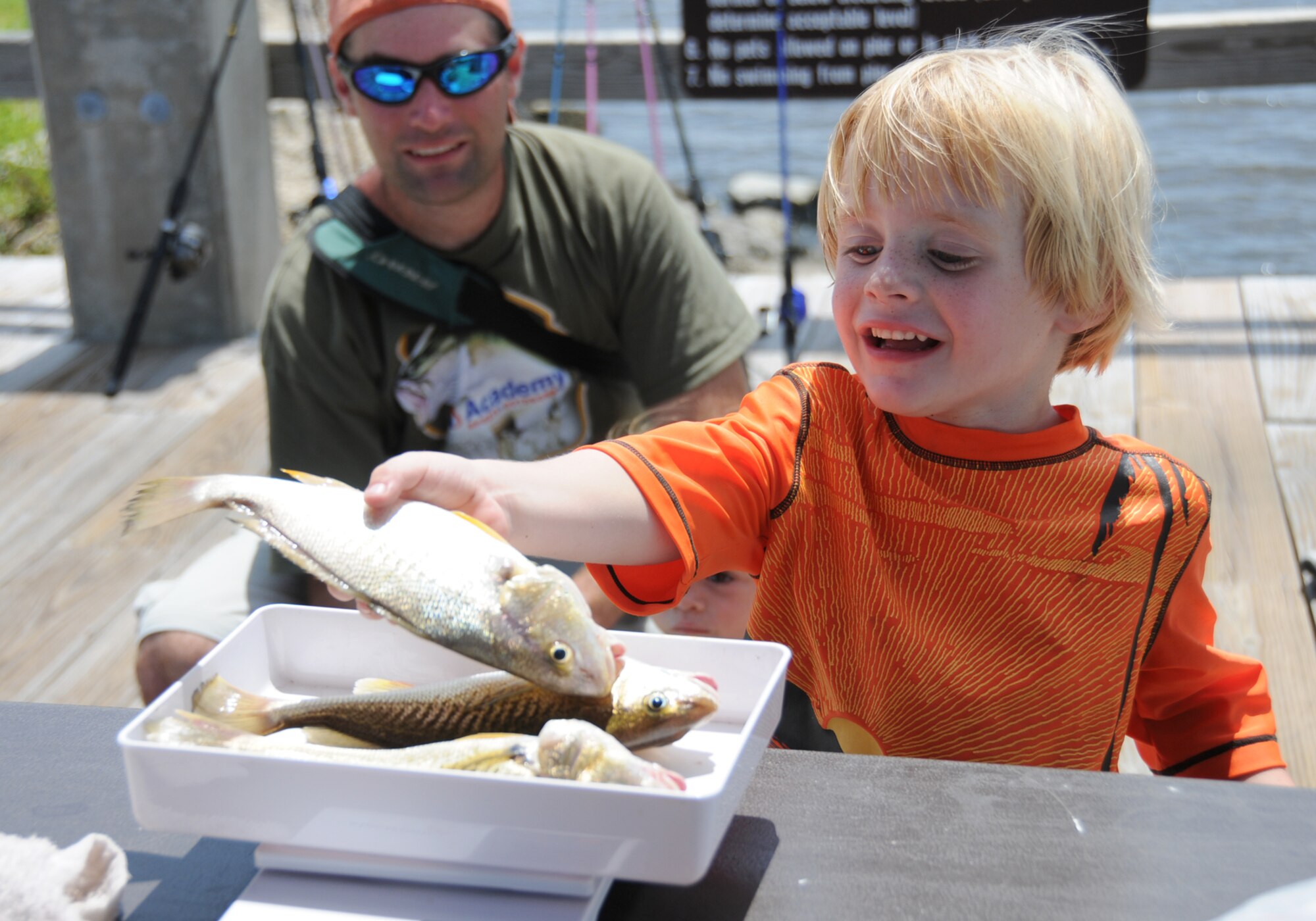 Four-year-old Joel Ahern places his three croakers on the scale during Saturday’s Kids Rishing Rodeo at the marina.  His dad, Jimmy Ahern, 335th Training Squadron, looks on.  (U.S. Air Force photo by Kemberly Groue)
