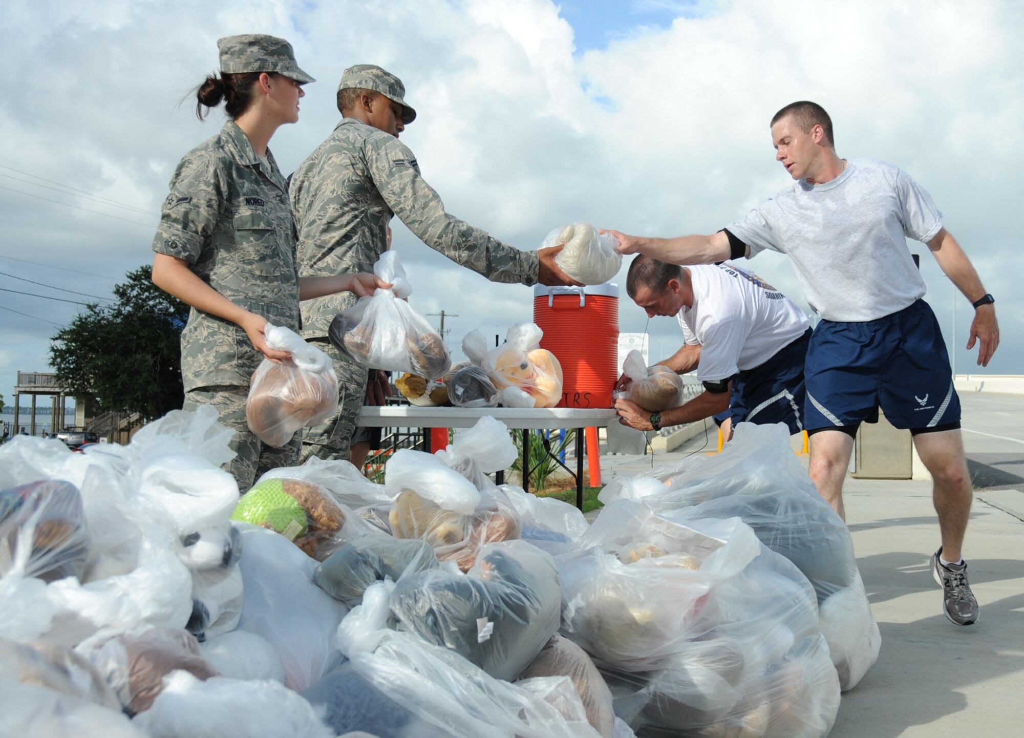 From left, Airman Stacy Nored and Airman 1st Class Phillip Honie, 332nd Training Squadron, pass teddy bears to Airmen 1st Class Matt Johnson, 334th TRS, and Jonathan Grote, 335th TRS, at Saturday’s Teddy Bear Run.  Runners started on the Biloxi end of the U.S. Highway 90 span, picked up stuffed animals on the Ocean Springs end and deposited them in the collection box at the Biloxi end.  The stuffed animals were donated to the Keesler Hospital’s pediatric unit.  (U.S. Air Force photo by Kemberly Groue)
