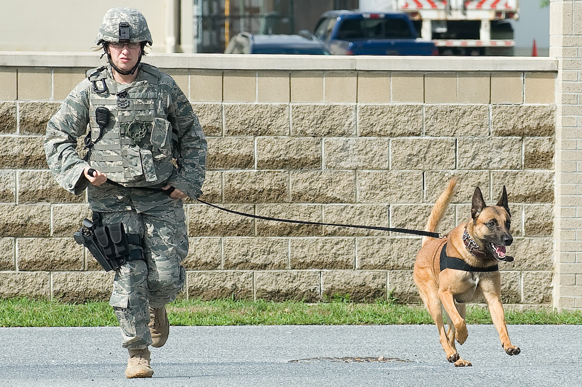 Staff Sgt. Ashley-Marie Wilson and Renzo responde to an urgent call during a Major Accident Readiness Exercise at the 436th Aircraft Maintenance Squadron parking lot on Dover Air Force Base, Del., July 15, 2010. The exercise Staff Sgt. Wilson and Renzo were participating in simulated a lone gunman being loose on the base. (U.S. Air Force photo by Jason Minto/Released) 