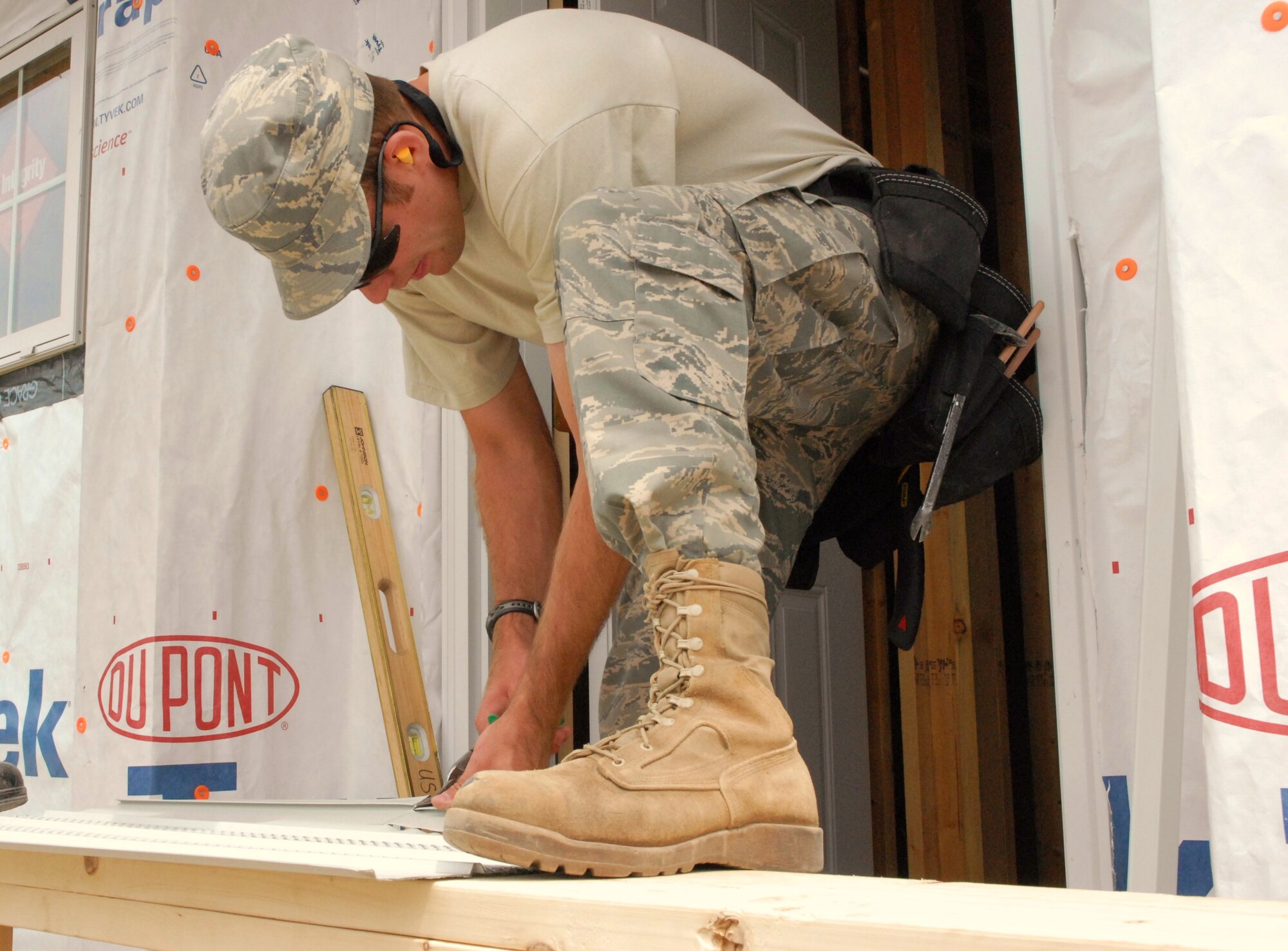 Staff Sgt. Grant Kohler, 940 CES structural, cuts a piece of panel to be fit and installed in the doorway on one of the houses being built on the Red Lake Reservation. (Photo/ Airman 1st Class Adam Hamar)