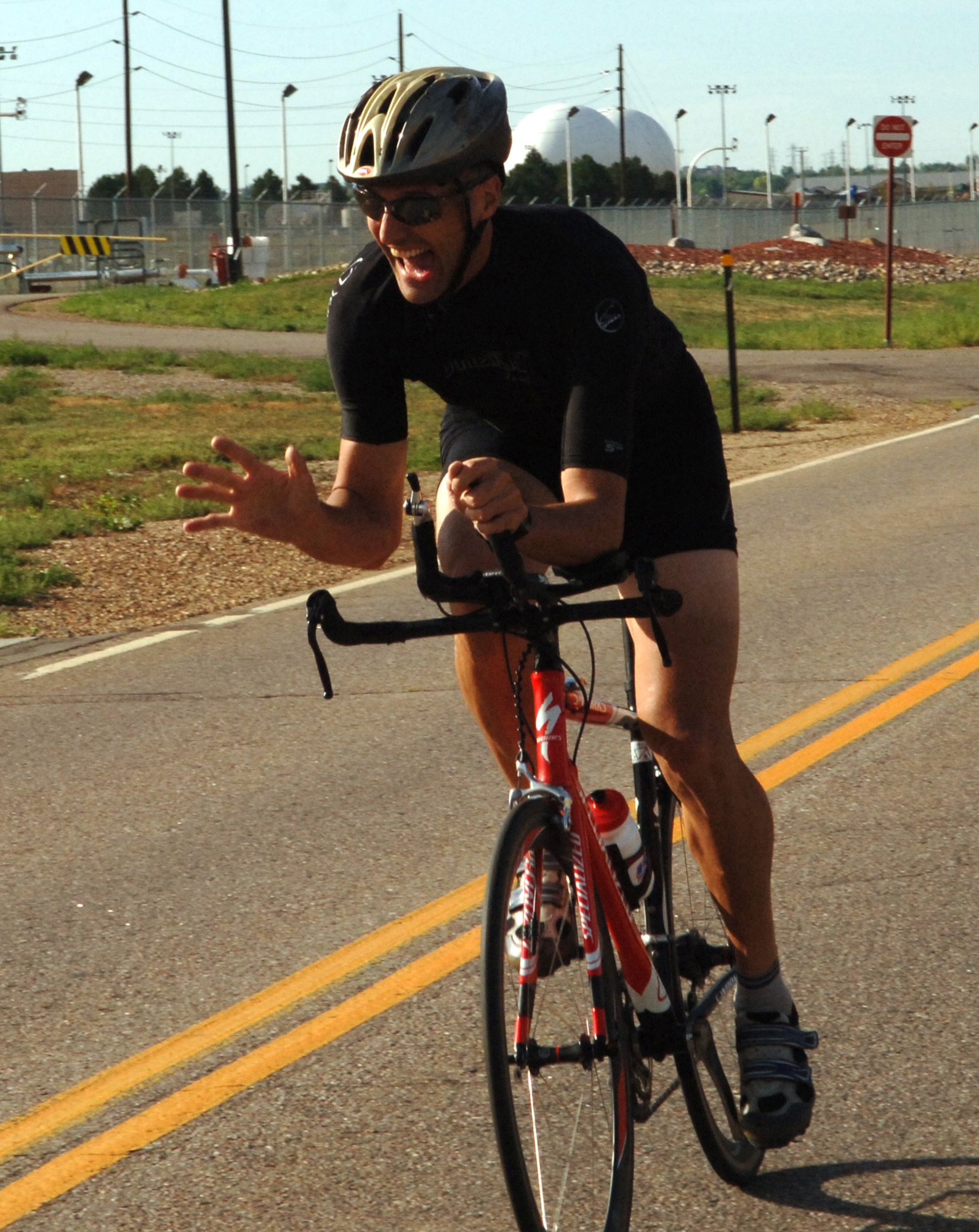 Lt. Col. Scot Spann, one of Team Buckley's premier bicyclists, waves to his fans during a mini-triathlon. The Mississippi Gate will be closed to bicyclists and pedestrians for safety reasons until the completion of the construction project in November. (U.S. Air Force photo by Tech. Sgt. Shirley Henderson)