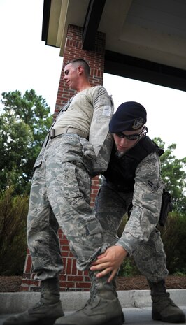 U.S. Air Force Airman 1st Class Michael Pugh performs a search of a mock suspect during an exercise at the Dorchester Road gate July 20, 2010, on Joint Base Charleston, S.C. The mock suspect was apprehended for transporting a firearm onto base and refusing to report to the base armory for storage. Failure to obey security forces instructions is a serious infraction and can result in arrest. Airman Pugh is an entry controller with the 628th Security Forces Squadron. (U.S. Air Force photo/Senior Airman Timothy Taylor)